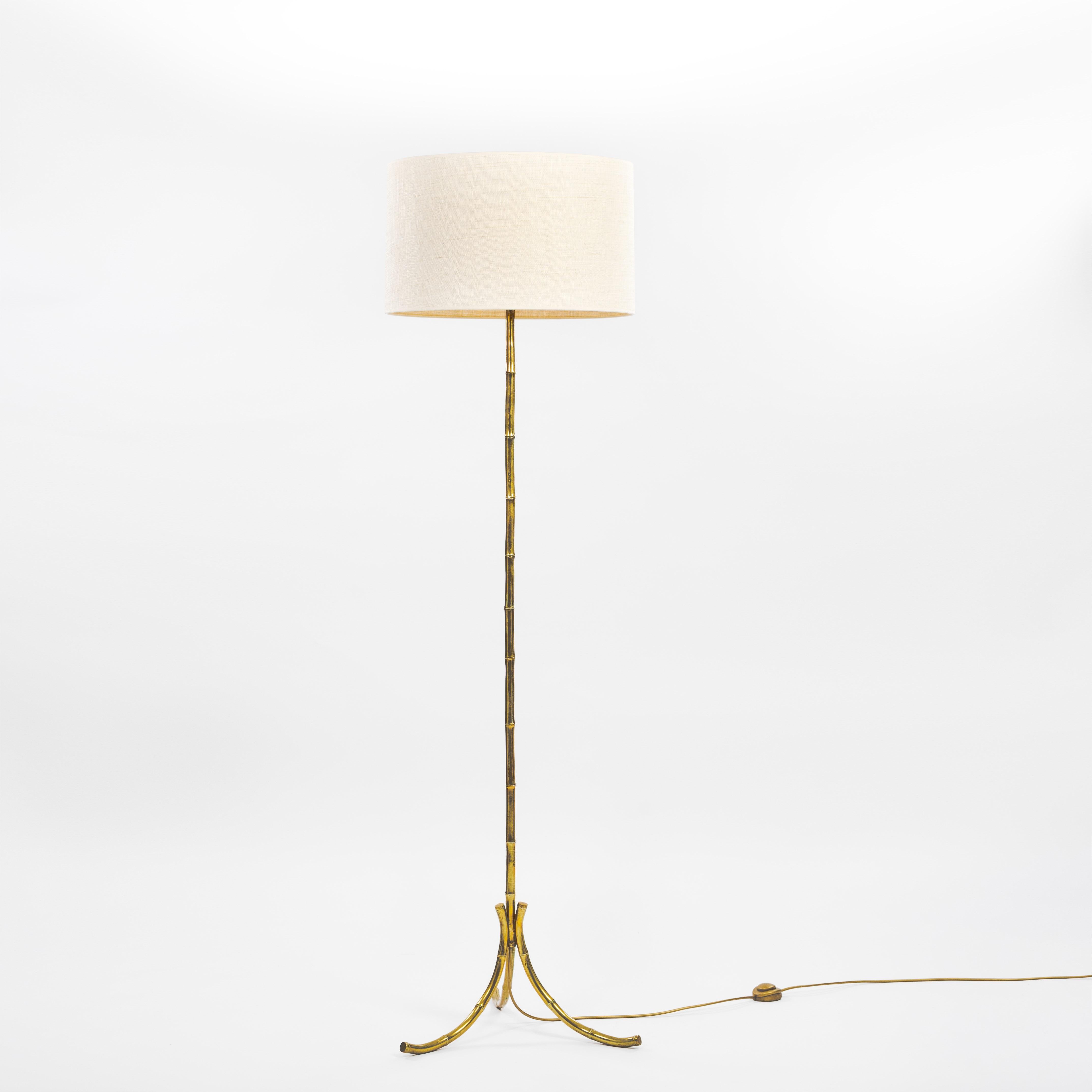 Mid-century bamboo look floor lamp on 3 legs by Maison Baguès.
The bamboo look brass trunk forms the base of the lamp and tapers off at the bottom to 3 curved foot ends.
Light-footed designed object with a naturalistic touch.
The straight shade made