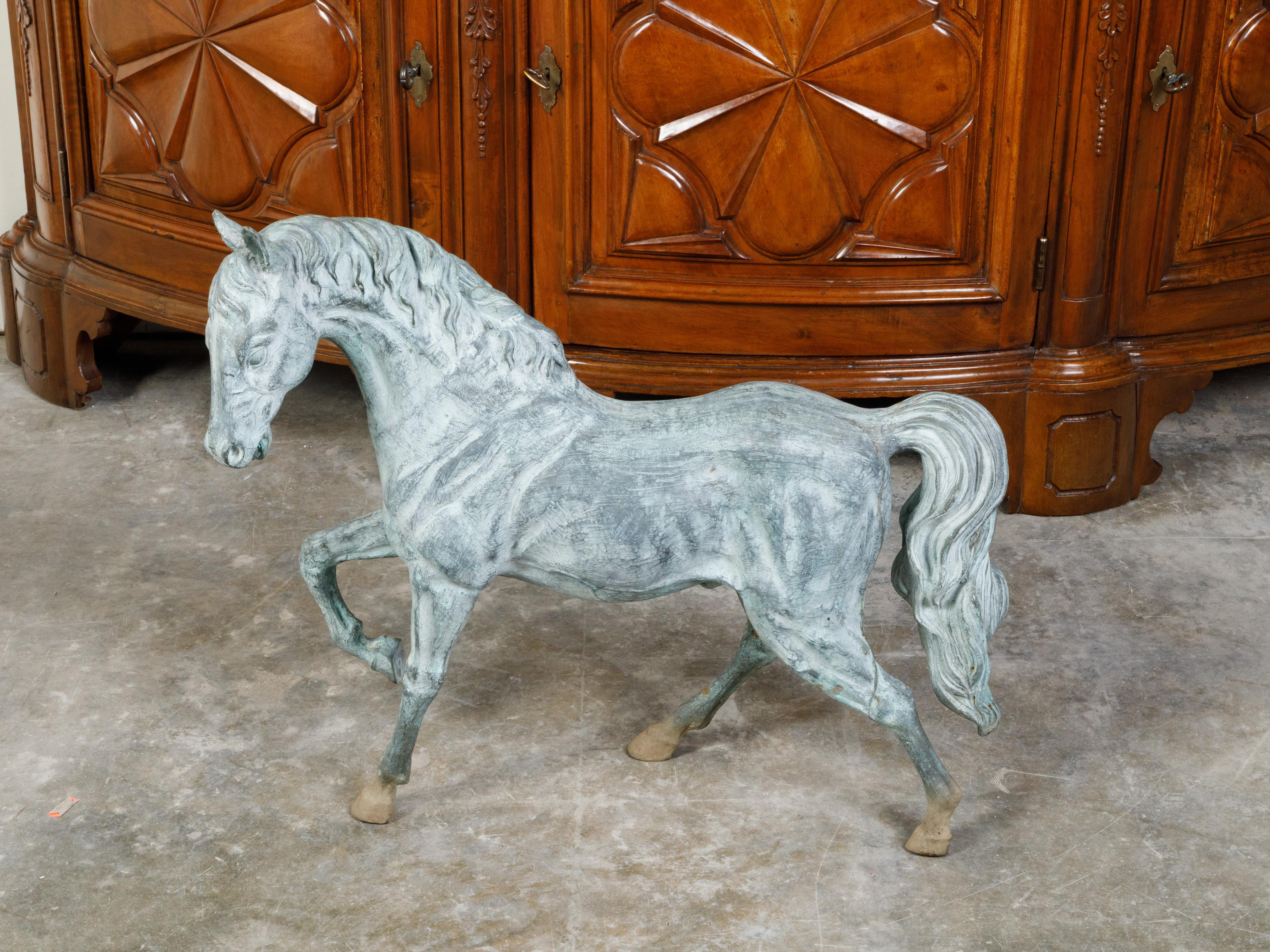 A French bronze horse statue from the mid 20th century, with great details and patina. Created in France during the Midcentury period, this bronze statue depicts an elegant horse with its front right hoof raised. Showcasing a great finesse in the