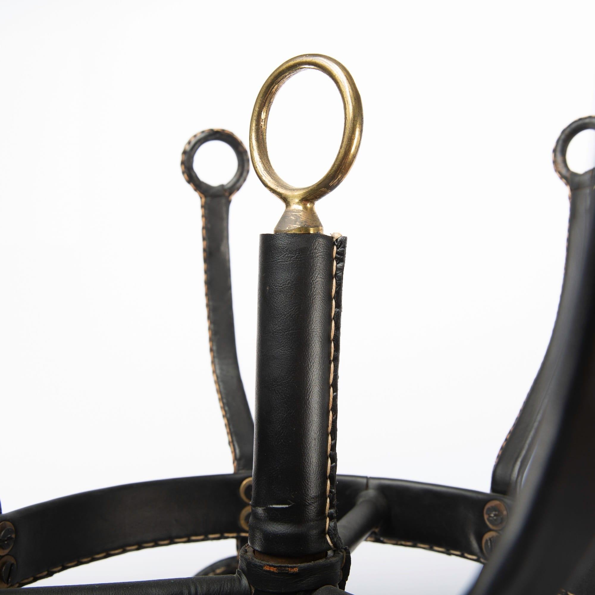 A beautiful coat hanger by Jacques Adnet (France), circa 1950.
Saddle stitched black leather work on a steel frame with brass accents.
Rare item, very clean condition.

Jacques Edouard Jules Adnet was born in Châtillon-Coligny France in 1900 and