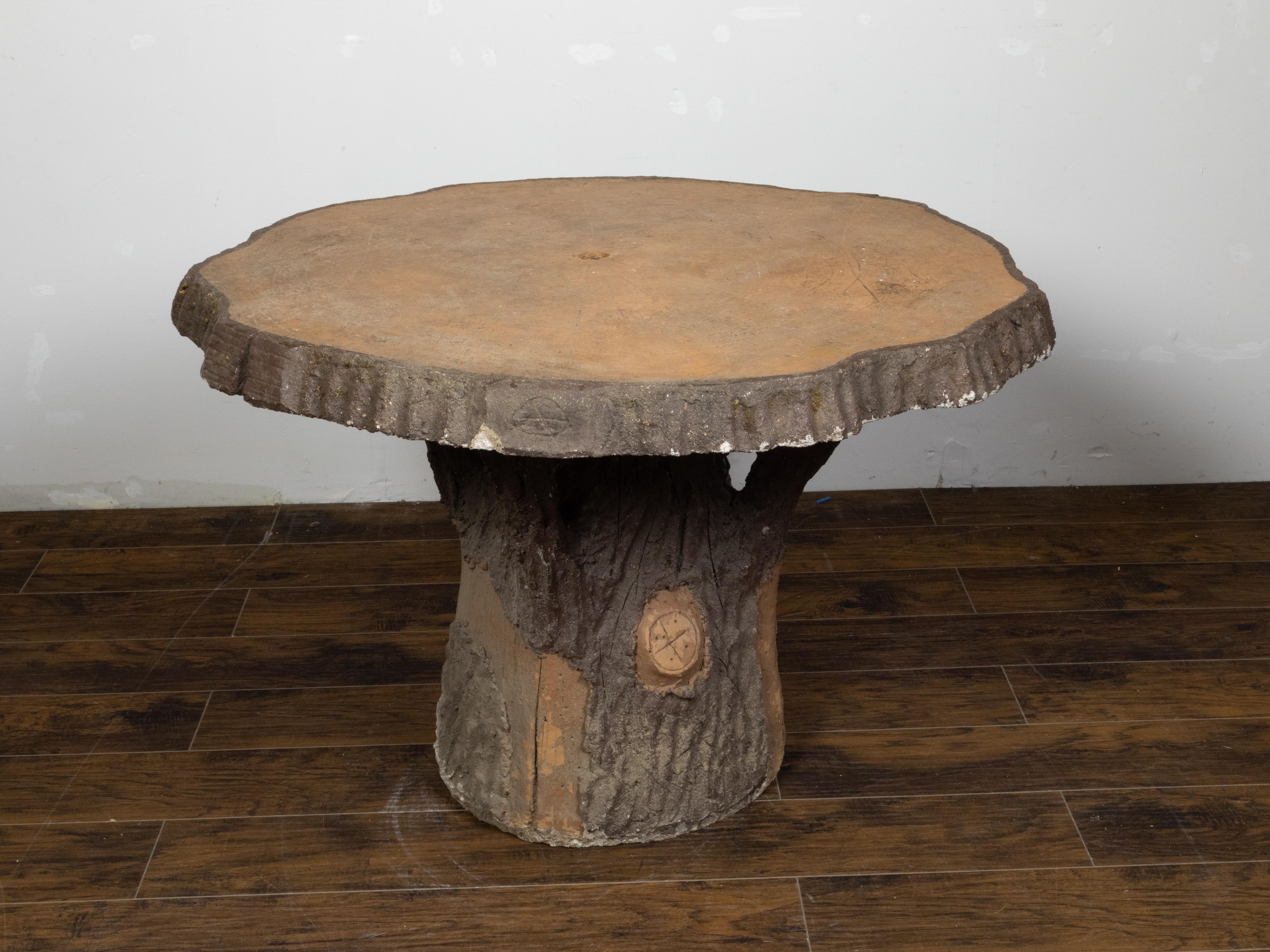 A French faux bois table from the mid 20th century, with round top and rustic appearance. Created in France during the midcentury period, this faux bois table features a circular wood slab top and tree trunk base. Particularly popular in France