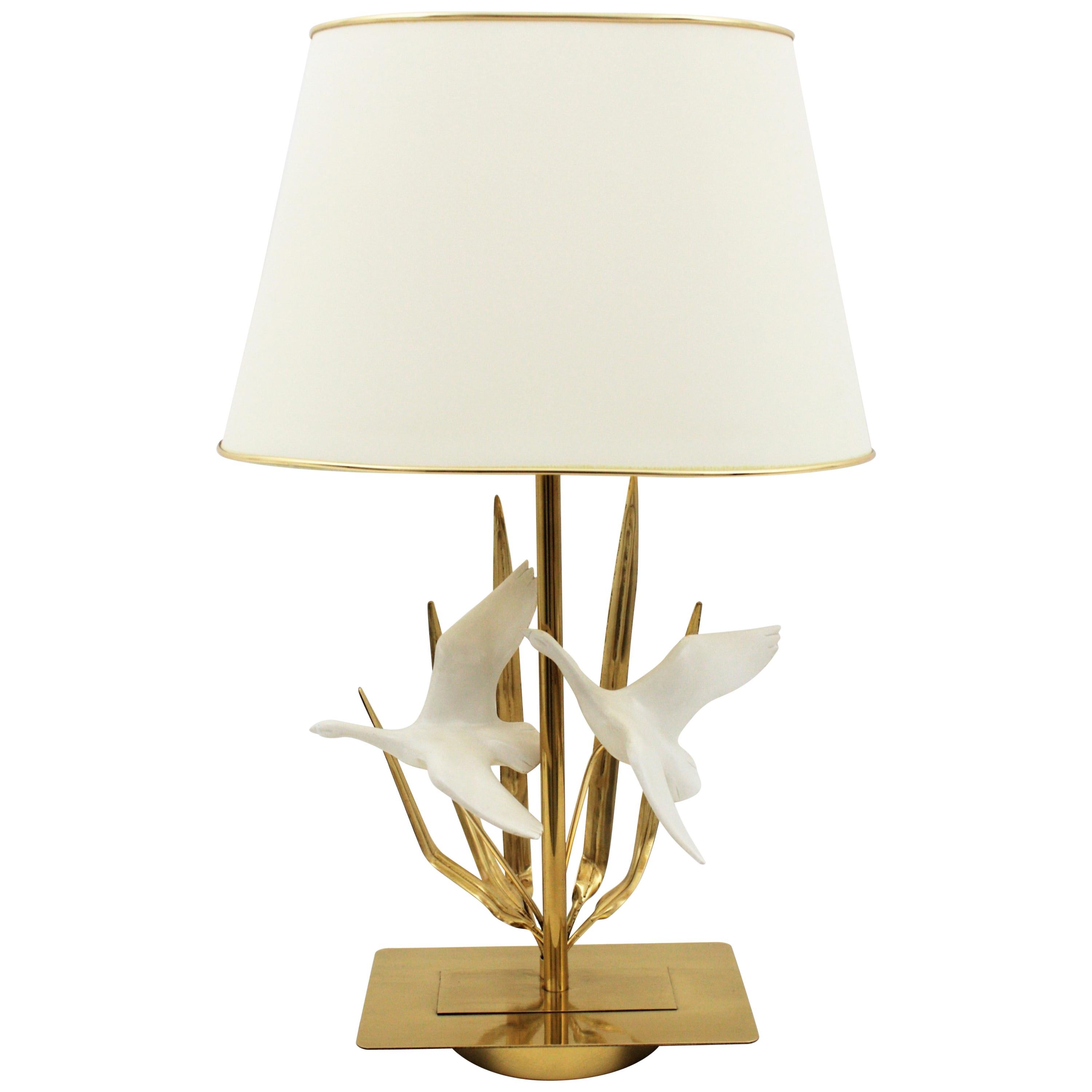 Lampe de table sculpturale en laiton du milieu du siècle avec des détails de feuilles et des oiseaux volants, France, années 1970.
La lampe est entièrement réalisée en laiton et est décorée de deux oiseaux en résine.
L'abat-jour est inclus.
Mesures