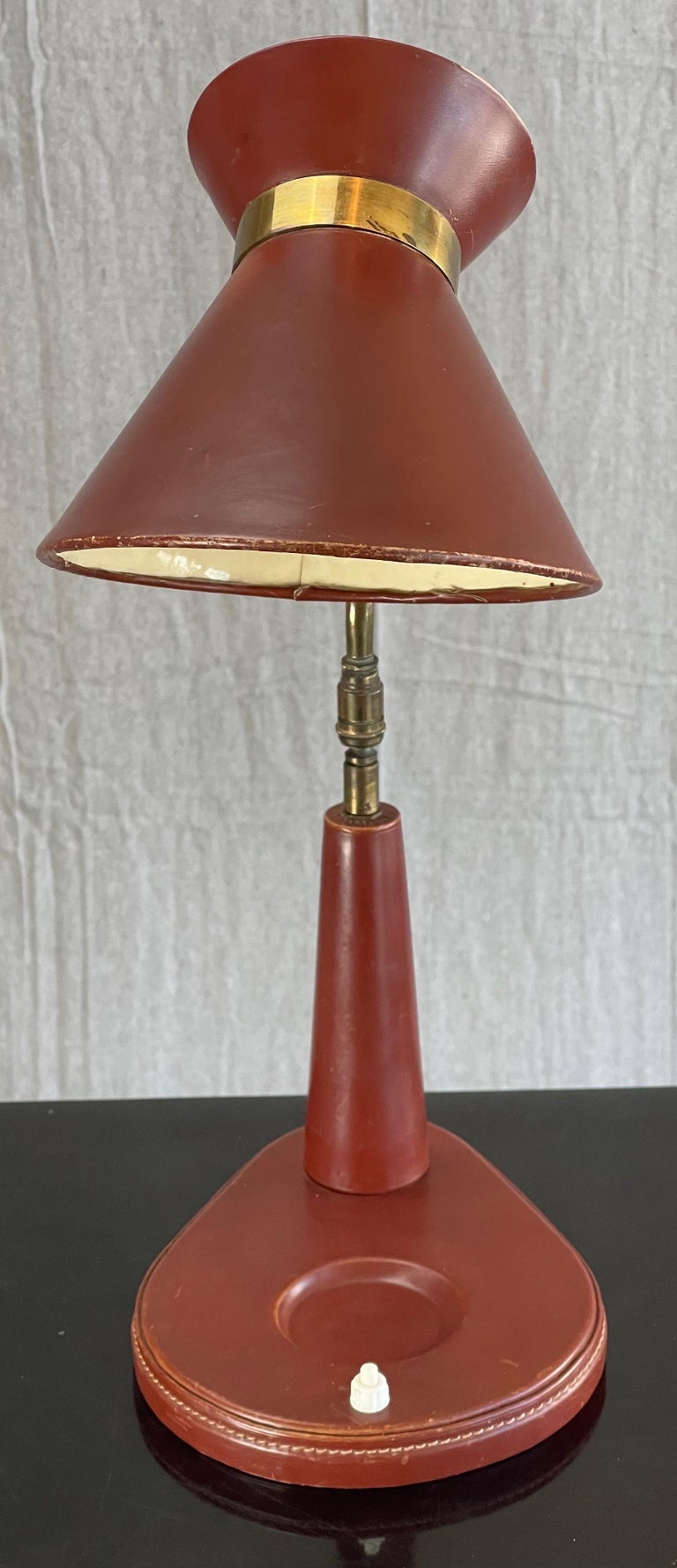 Here we have an excellent example of French Midcentury craftsmanship; A Jacques Adnet table lamp in hand stitched whiskey coloured leather. Jacques Adnet design is marked with the now iconic “Stiched Leather” style. This lamp has been lovingly used