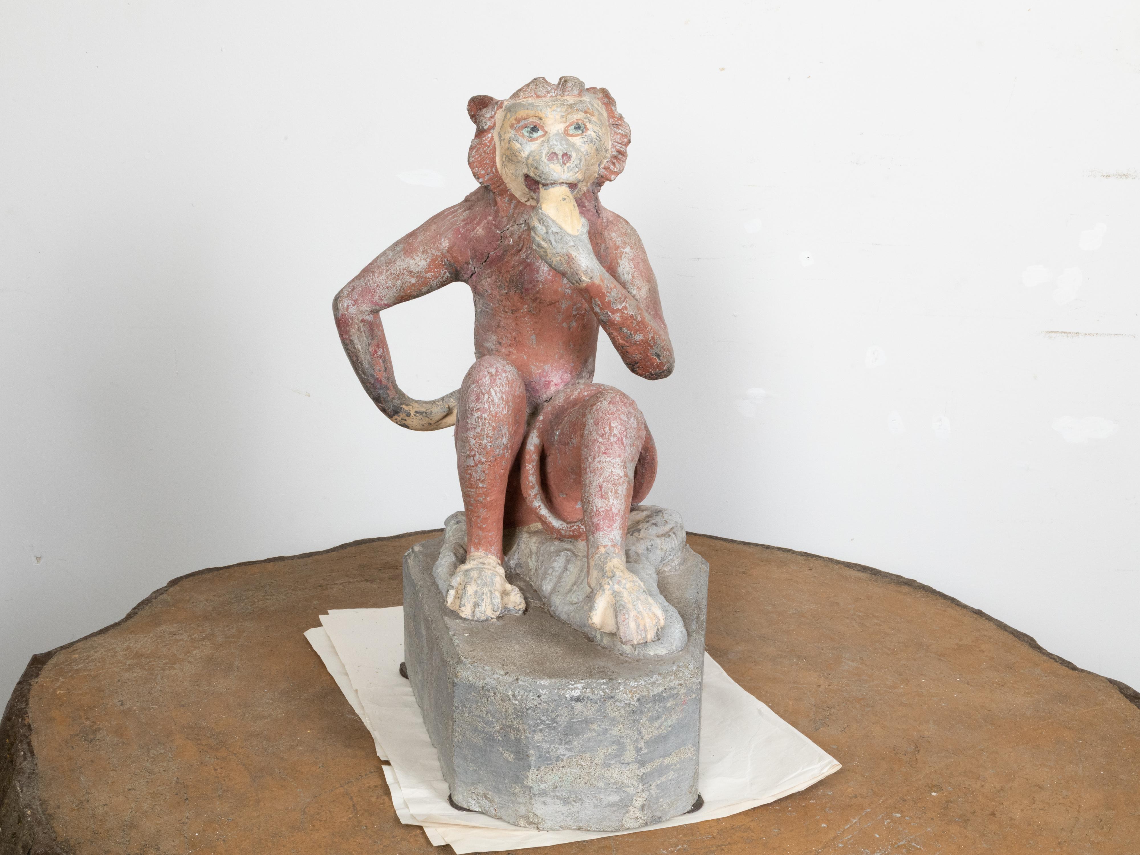 A French lead sculpture from the mid 20th century, depicting a monkey eating a banana. Created in France during the midcentury period, this lead sculpture attracts our attention with its anthropomorphic depiction of a monkey eating a banana. Seated