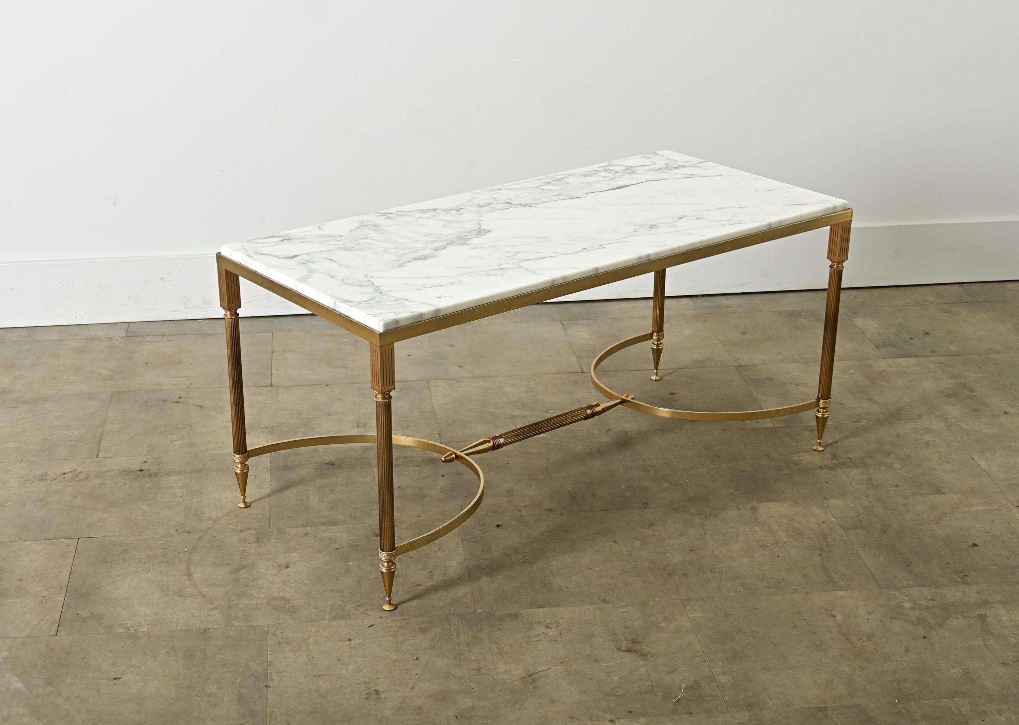 Vintage, midcentury French brass and marble coffee/cocktail table in the style of legendary firm Maison Jansen to add instant glamor to a room. Reflecting the typical aesthetic codes of Hollywood Regency taste, the polished brass frame is given a