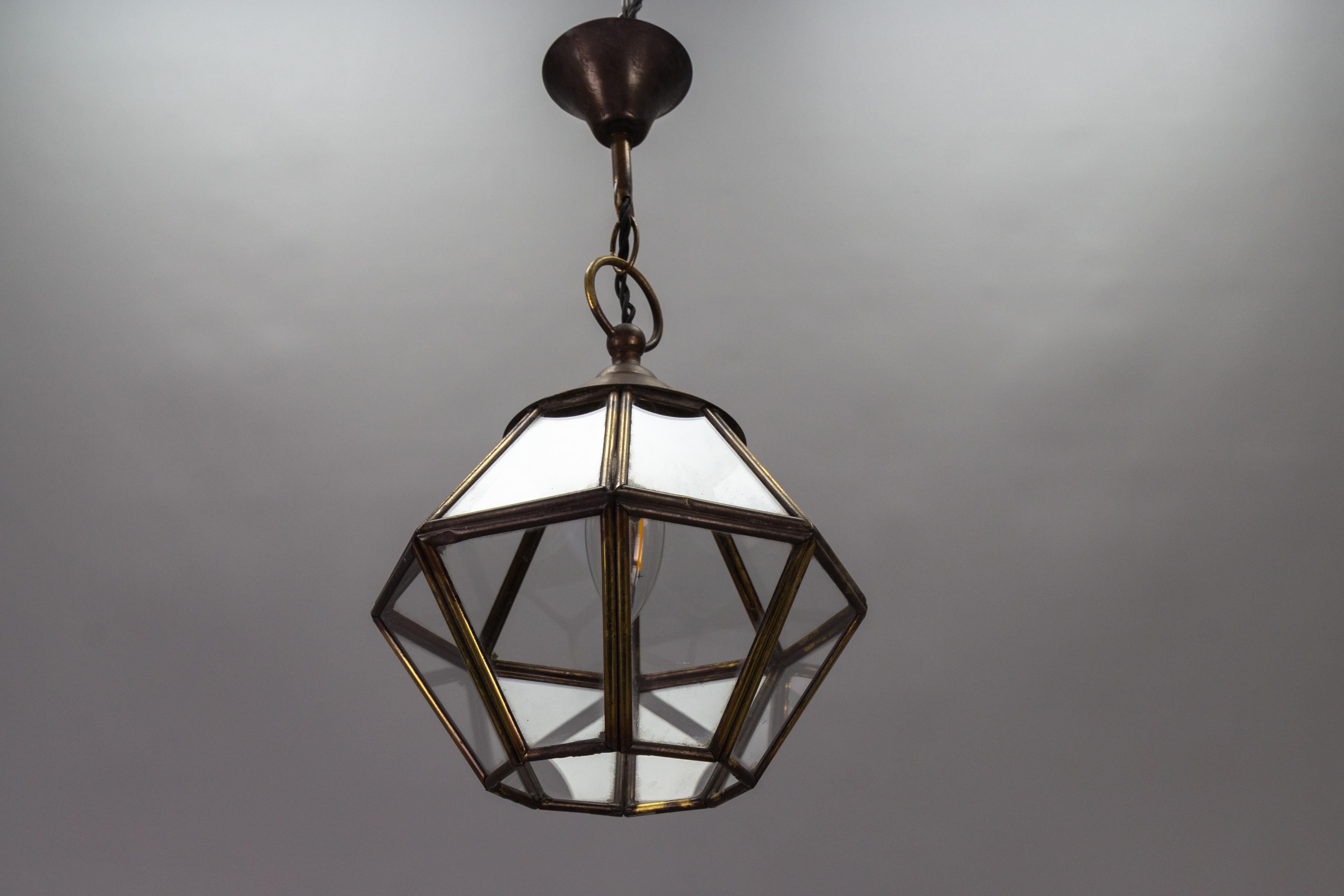 French Midcentury-Modern brass and clear glass octagonal hanging lantern from circa the 1950s.
This adorable and compact vintage single-light pendant lantern features an octagonal brass frame with clear glass panels.
One socket for B22 size light