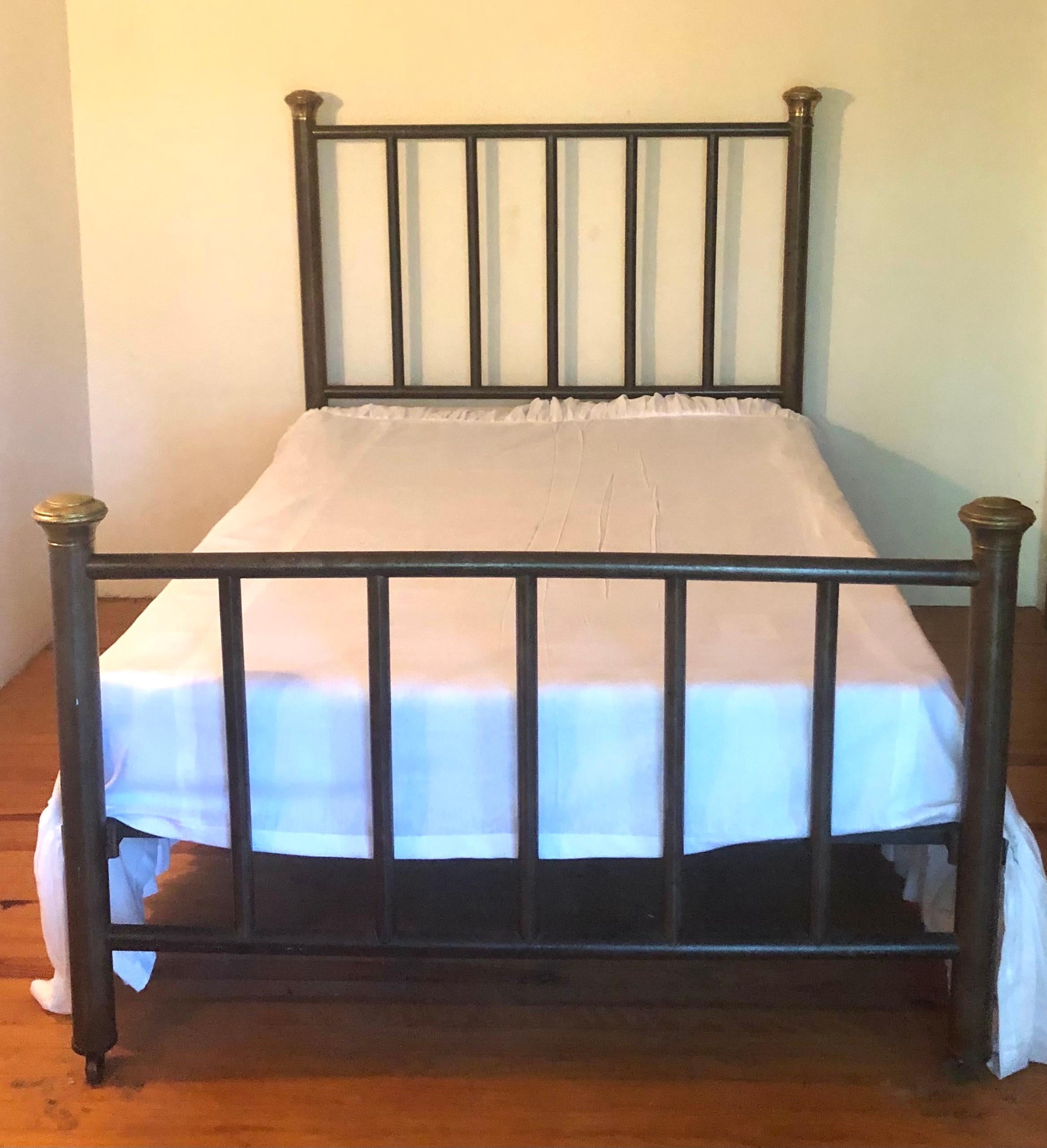 A French modern neoclassical bronzed iron and brass full bed, circa 1930. Tasteful, strong and in very good working condition, it has a bronzed iron frame with brass capitals on each bedpost. 

The dimensions of the frame are H 58.5 (36 footboard