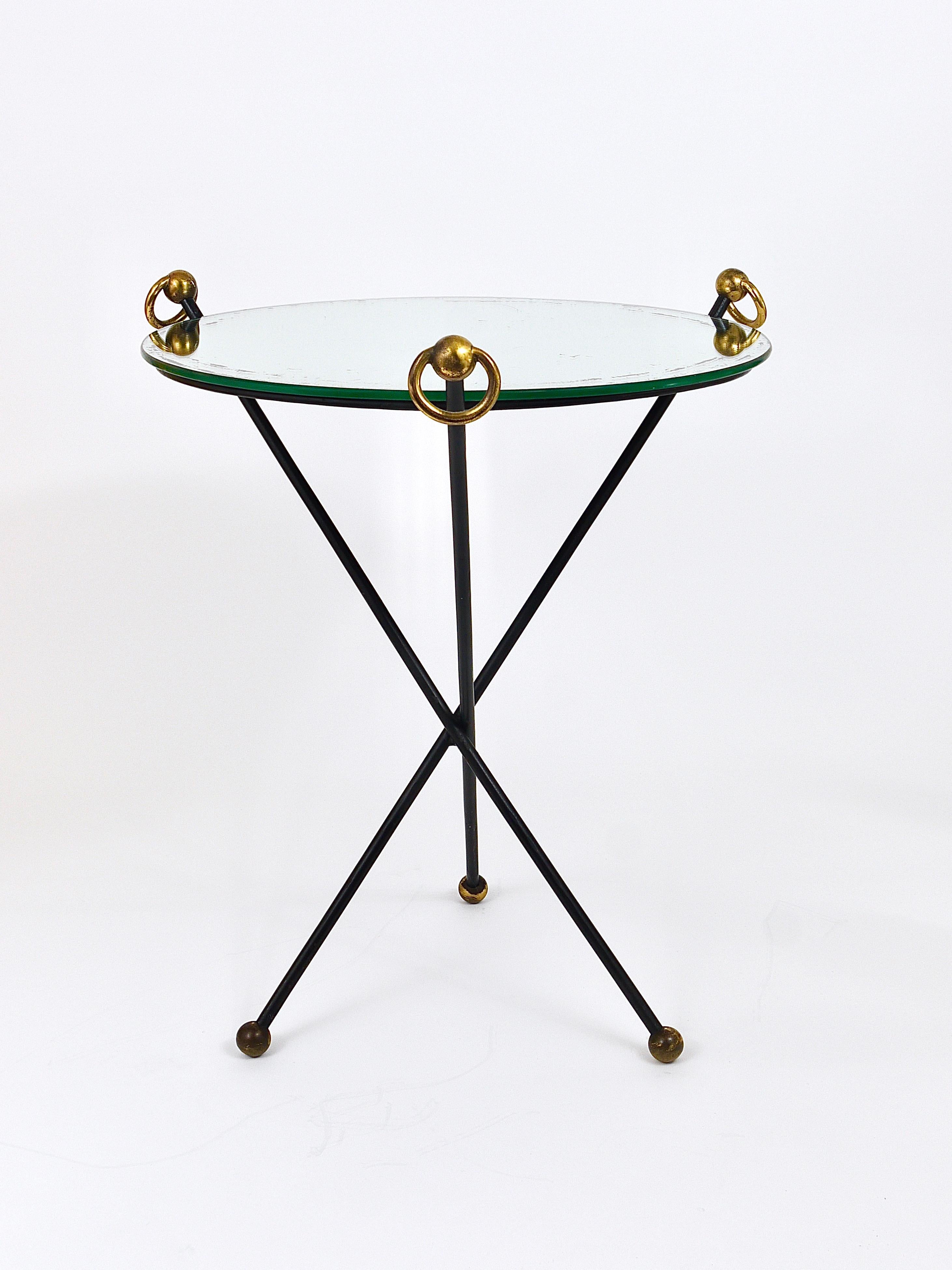 Une jolie et élégante petite table d'appoint ou table basse / guerdon / piédestal néoclassique des années 1950, fabriquée à la main en France. Dans le style de Jacques Adnet. Elle se compose d'une base de table tripode classique en fer noir avec de