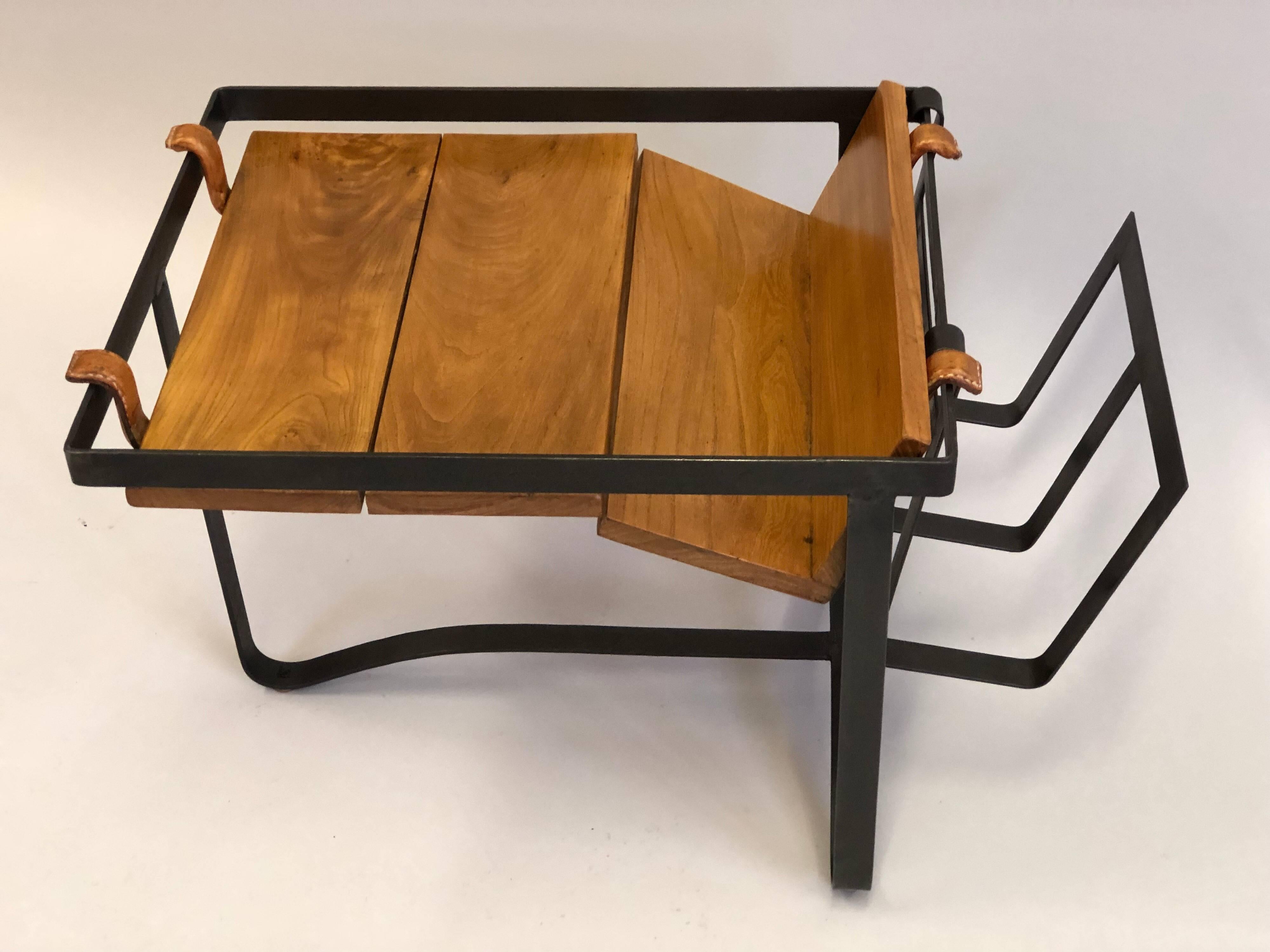 Rare, elegant French Mid-Century Modern side table or magazine rack by Jacques Adnet in wrought iron / steel, wood and leather.

The wrought iron / steel base is tripod in form and originally was covered in leather; a slatted solid wood top is