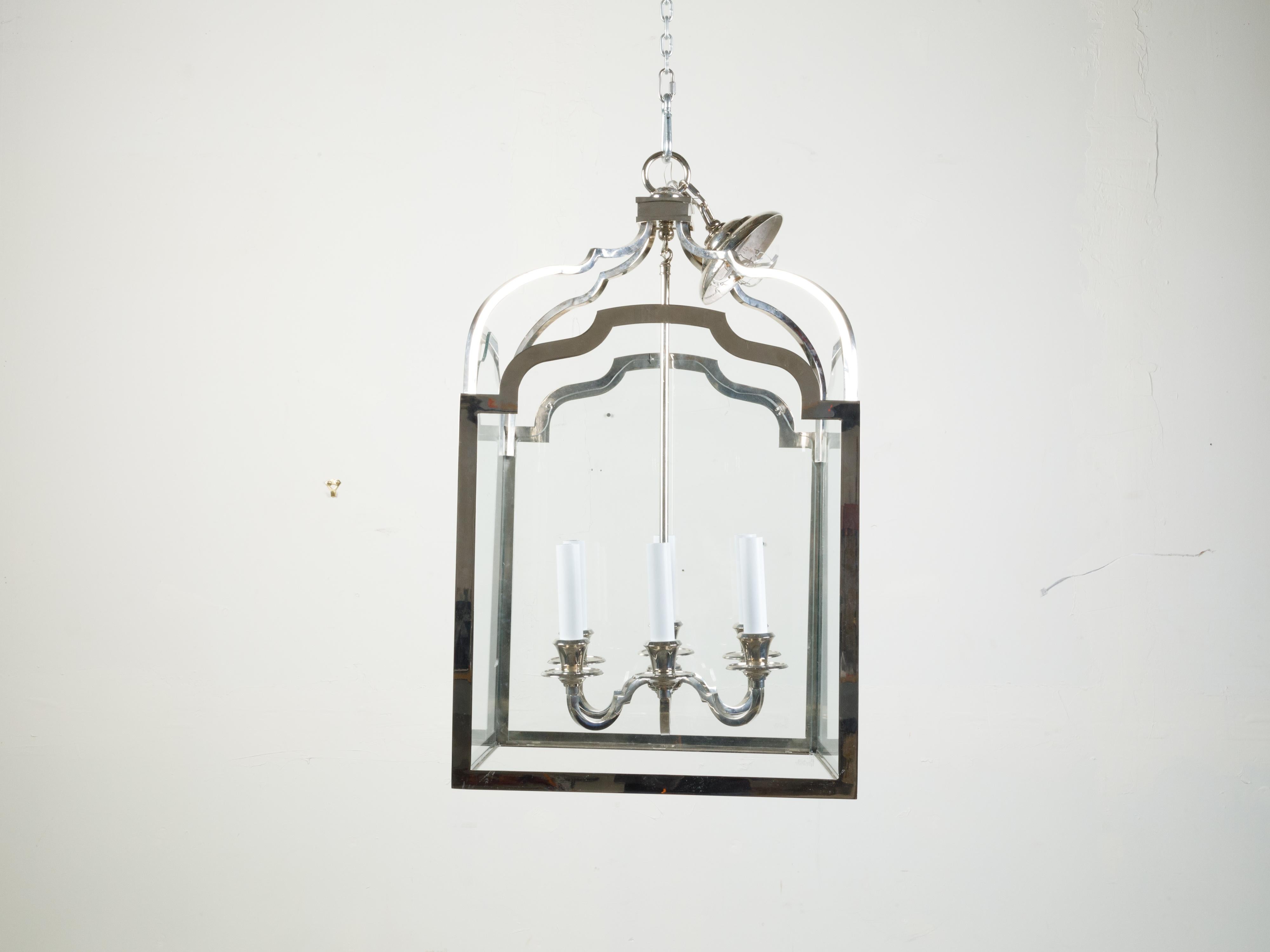 A vintage French nickel six-light lantern from the mid 20th century, with shaped glass panels. Created in France during the midcentury period, this lantern features six scrolling nickel arms connected to a central shaft, secured behind glass panels