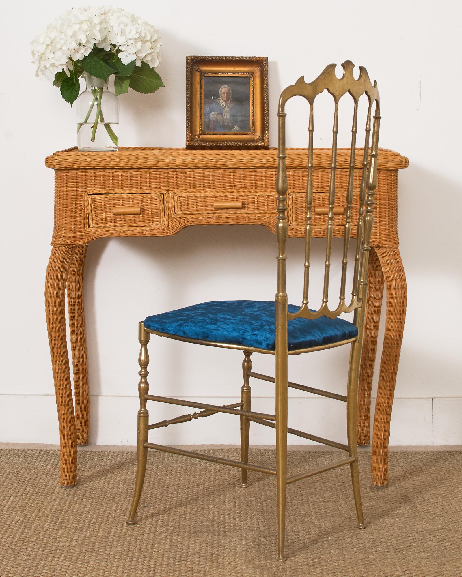 Charming mid-century organic modern vanity desk or dressing table featuring a wooden frame covered with woven wicker. The vanity has a clamshell style flip-top to reveal a large storage area below with a spectacular framed mirror. The vanity is