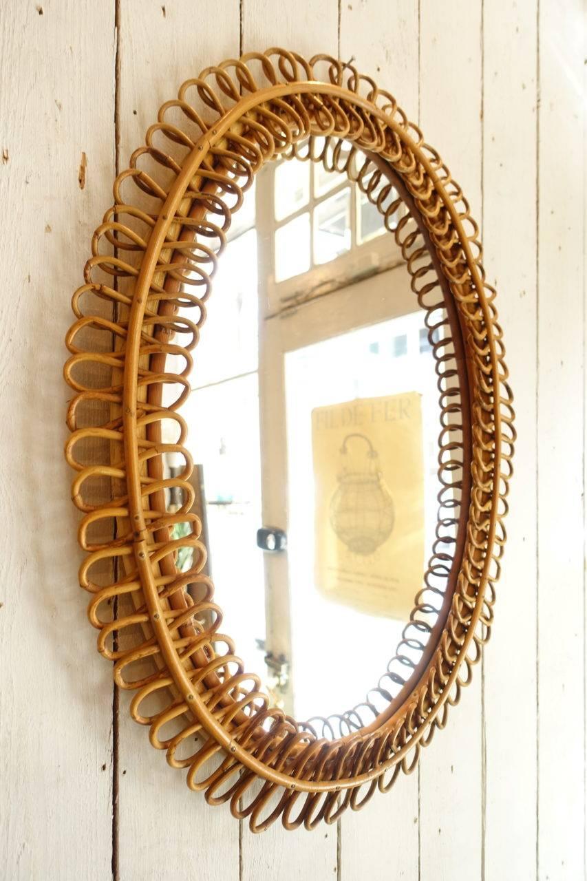 Wonderful vintage midcentury oval French rattan or wicker mirror. With its original glass and pretty frame. Hand weaved in a stylish fashion, circa 1950s. Super decorative and spot on for today’s interior tendencies.