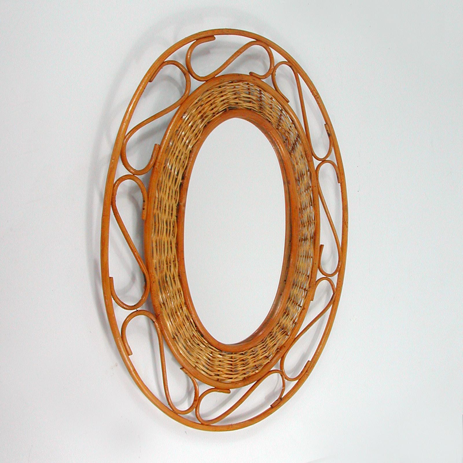 This vintage Franco Albini style wall mirror was made in France in the 1950s. It features an undulated rattan and wicker oval frame.

Condition is good with signs of age. Rattan with some wear. The mirror glass has been replaced and is new.