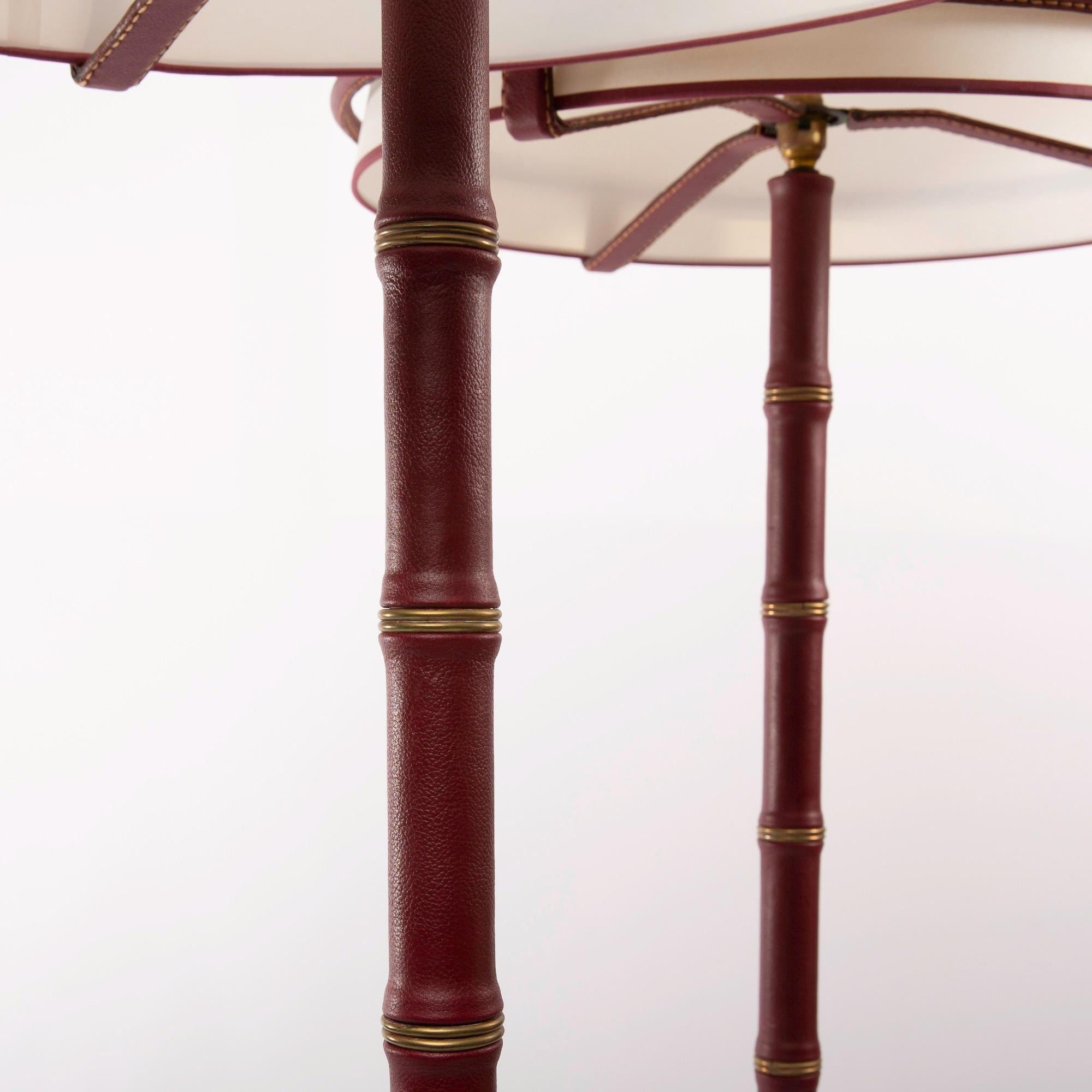 A fine pair of floor lamps designed by Jacques Adnet and manufactured by Compagnie des Arts Français.
The structure of theses lamps are made of steel and covered with saddle stitched burgundy leather.
The lampshades are simply placed on the