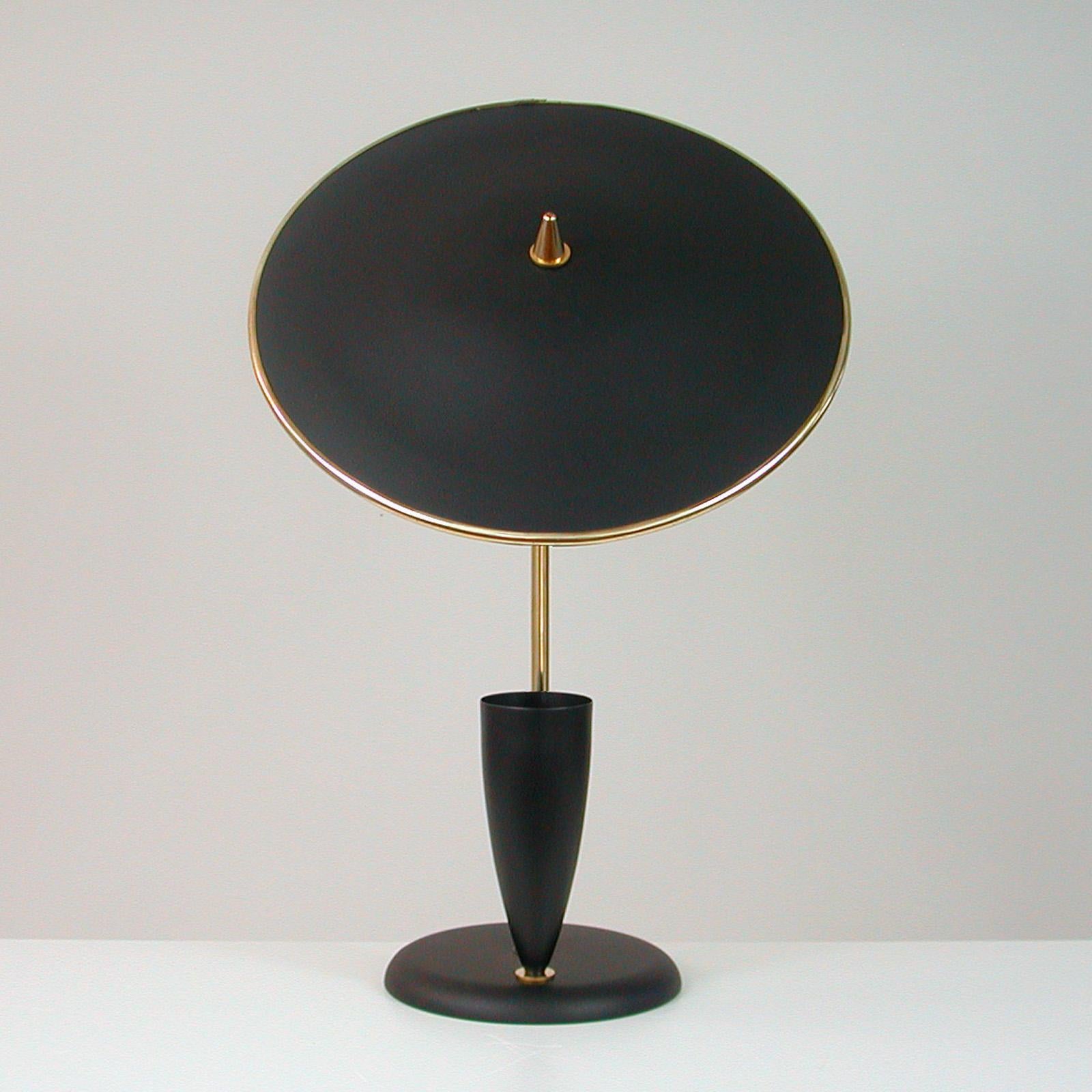 Diese elegante Tischleuchte im Stil von Maison Arlus wurde in den 1950er Jahren in Frankreich entworfen und hergestellt.

Sie verfügt über einen schwarzen, verstellbaren, reflektierenden Lampenschirm, einen Lampenarm aus Messing und eine schwarze