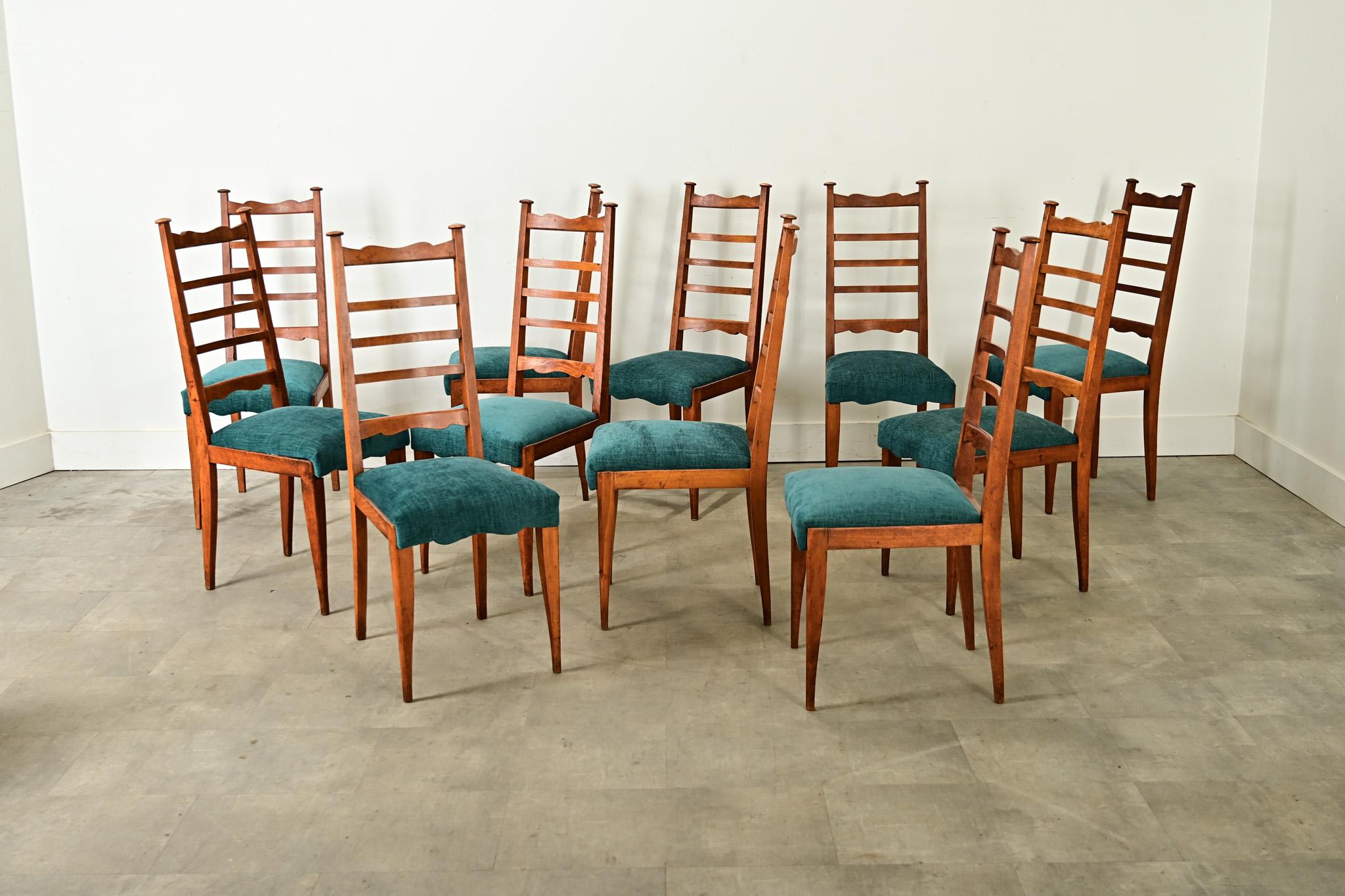 Un set molto insolito di undici (11) sedie da pranzo francesi della metà del XX secolo che danno una svolta al classico stile ladderback applicando alcune proporzioni creative e tecniche di intaglio alle strutture in legno di frutta. Alti e