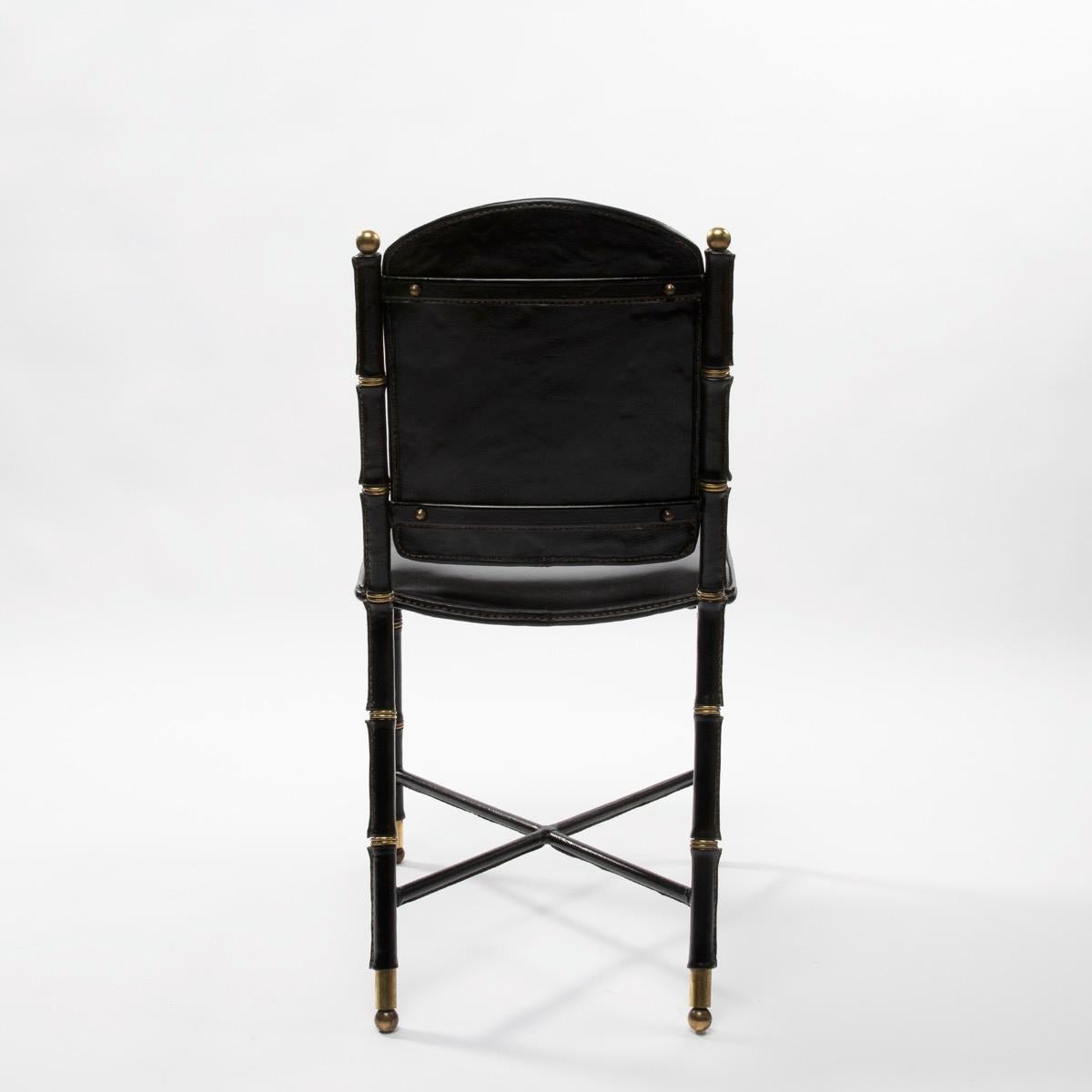 A very elegant set of 6 saddle stitched black leather chairs by Jacques Adnet. The chair consist of a sheathed leather steel frame and a padded seat.
The feet are embellished with bronze accessories. Manufactured by 