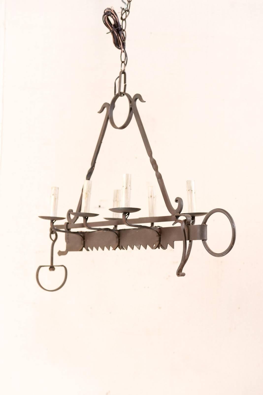 A French midcentury, six-light forged-iron chandelier made from a 19th century spit-jack. A spit-jack is a type of rotisserie that was once common in fireplaces. This chandelier has six arms, three lifting up and out along each long side of the