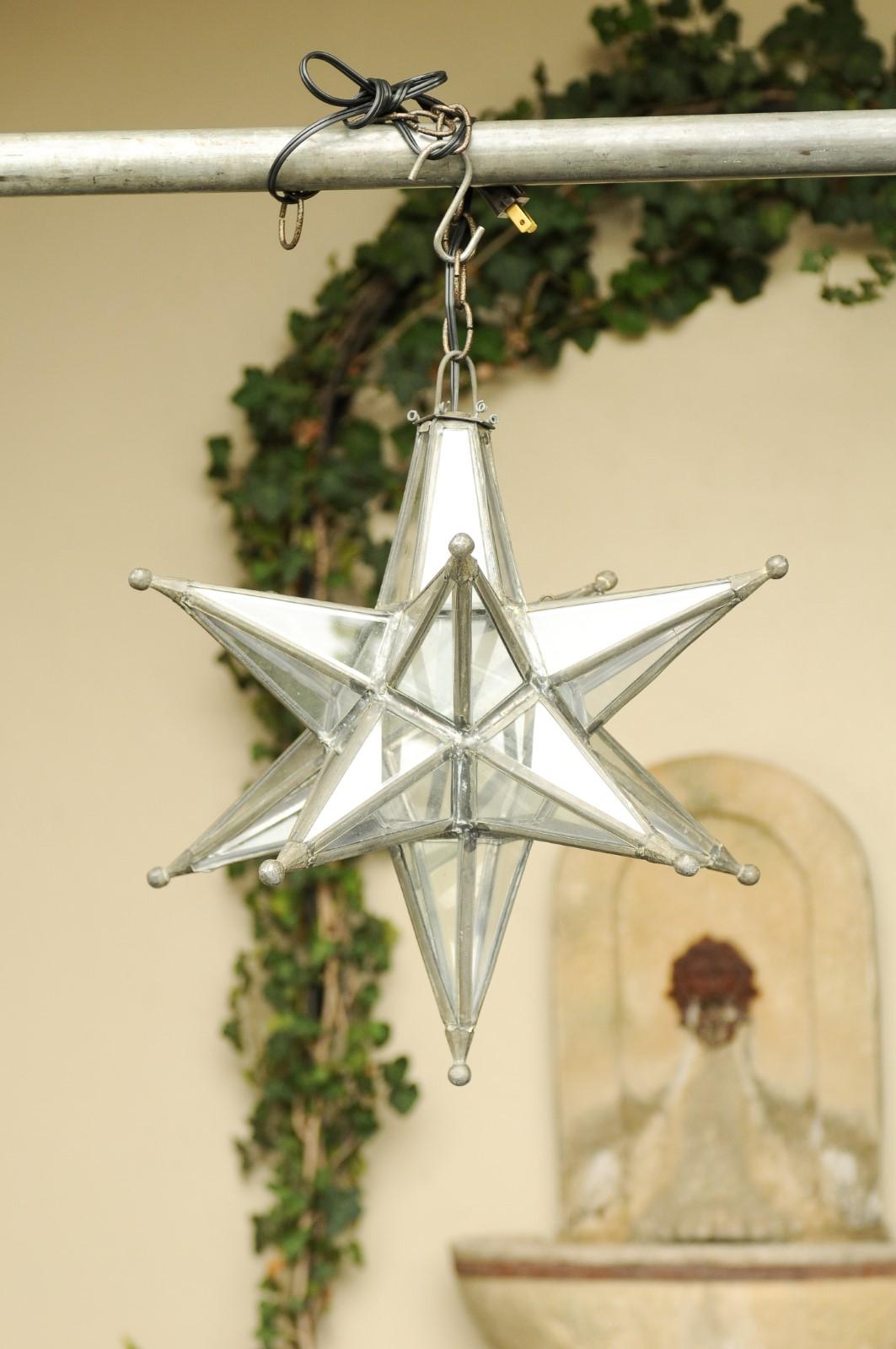 A vintage French star light fixture from the midcentury modern, with lead glass panels and metal frame. This French light fixture features an energizing star shape accented by a metal frame adorned with small spheres in the extremities which secure