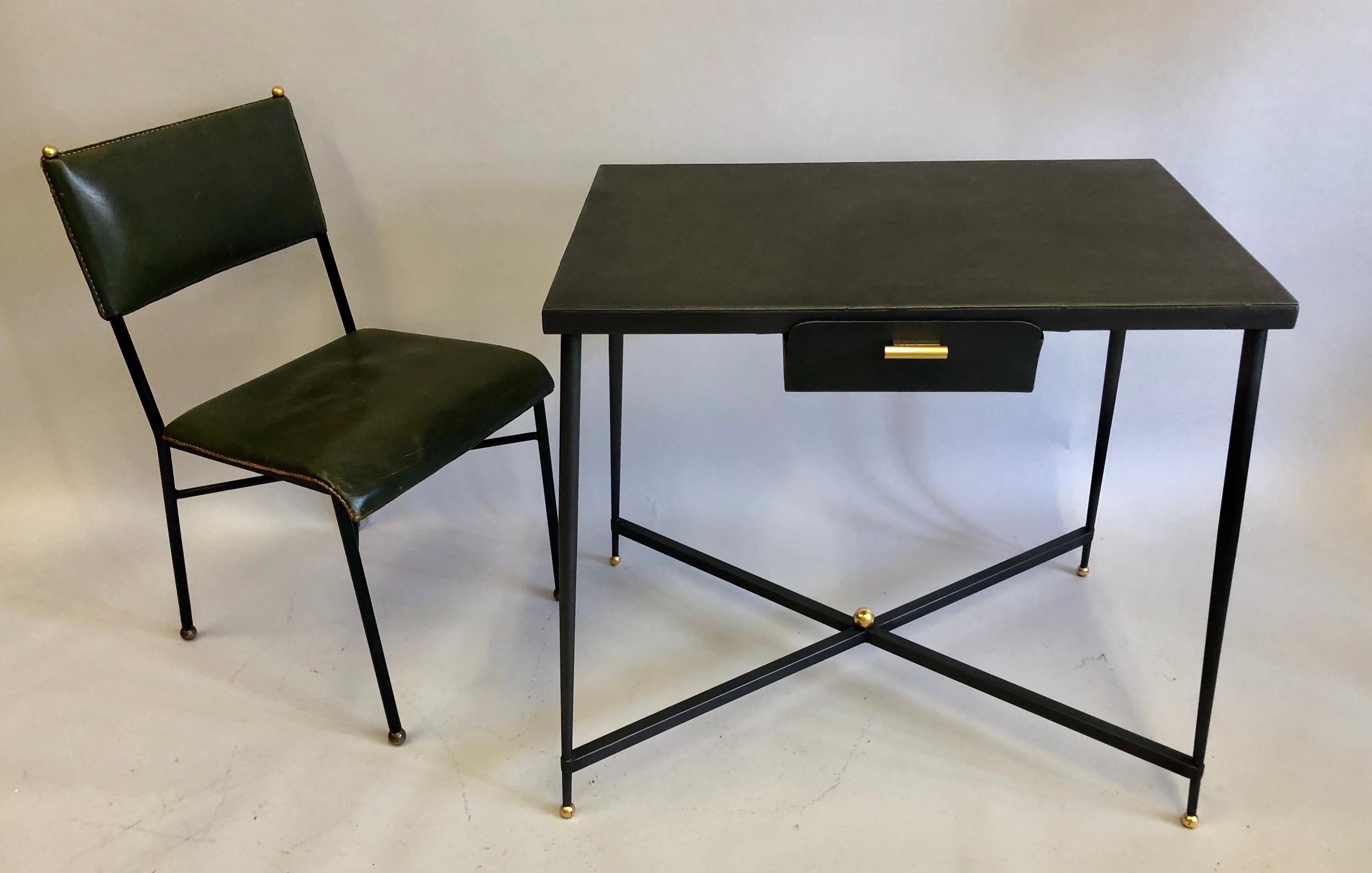 Sober, elegant, French modern Neoclassical desk or writing table in handwrought iron with iron pencil drawer and brass drawer pull.

The piece features four elegantly gently tapering legs that terminate in gilt ball feet and are united by X-form