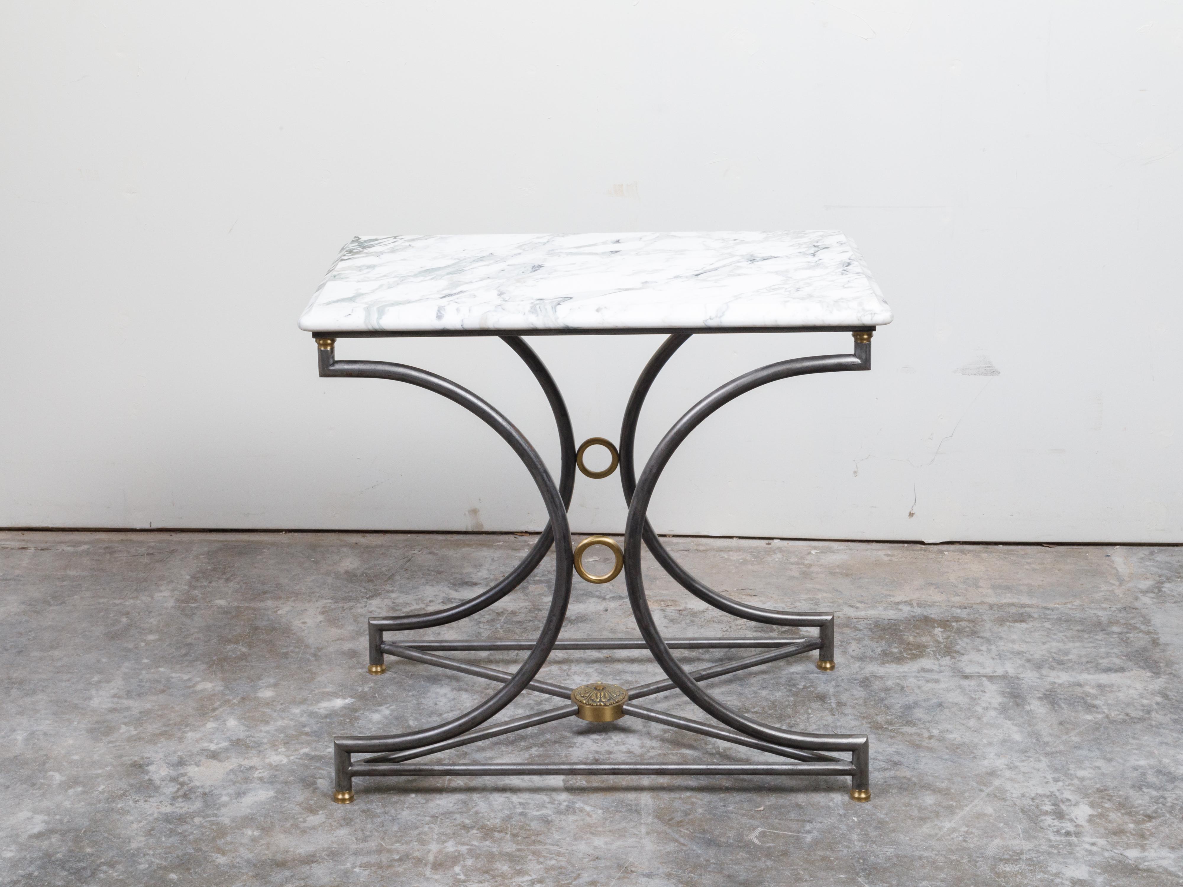 A French steel and bronze console table from the mid 20th century, with marble top and rosette medallion. Created in France during the midcentury period, this console table features a rectangular white veined marble top with rounded corners and