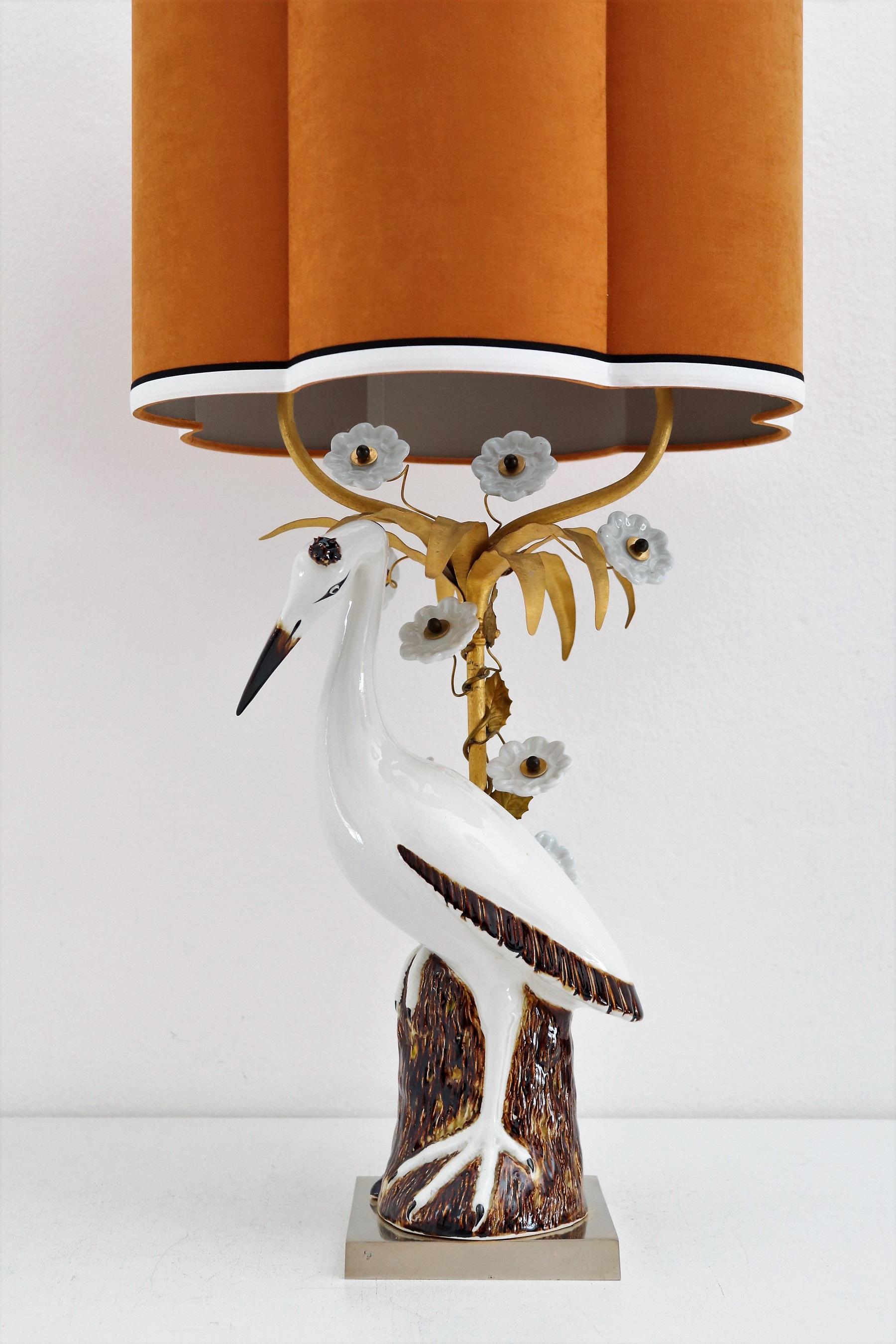 Magnifique lampe de table en forme de grue ou de héron, fabriquée en porcelaine peinte à la main.
Fabriqué en France dans les années 1960 et 1970.
La figurine en porcelaine de type grue - héron est posée sur un socle en métal doré devant une barre