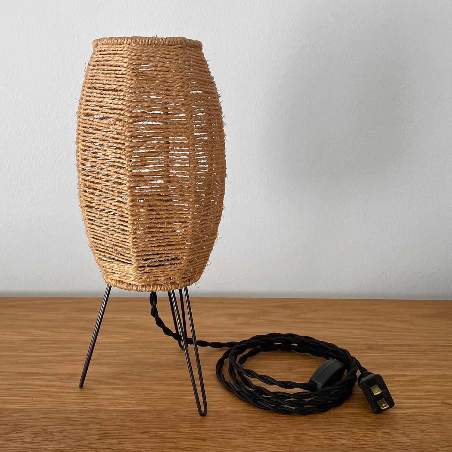 French midcentury tripod lamp
Impeccably woven jute strands band around the petite frame 
Minimalist hairpin legs 
Newly rewired
Black french twist silk cord
Cord length 5’ 8”