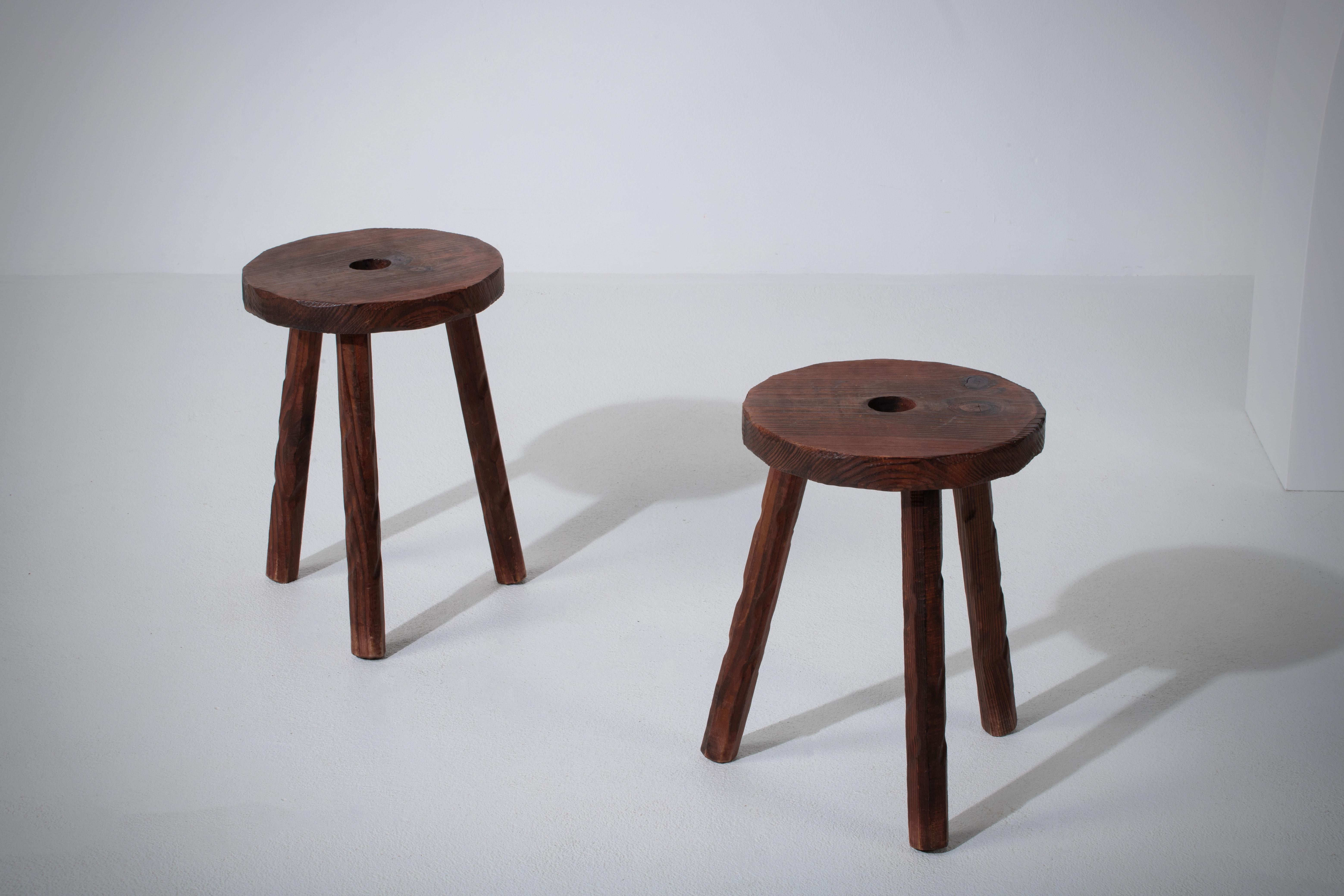Fantastic wood pair of stools from France in the style of Jean Touret. Made in the 1960s with three legs. No hardware. Good vintage condition.