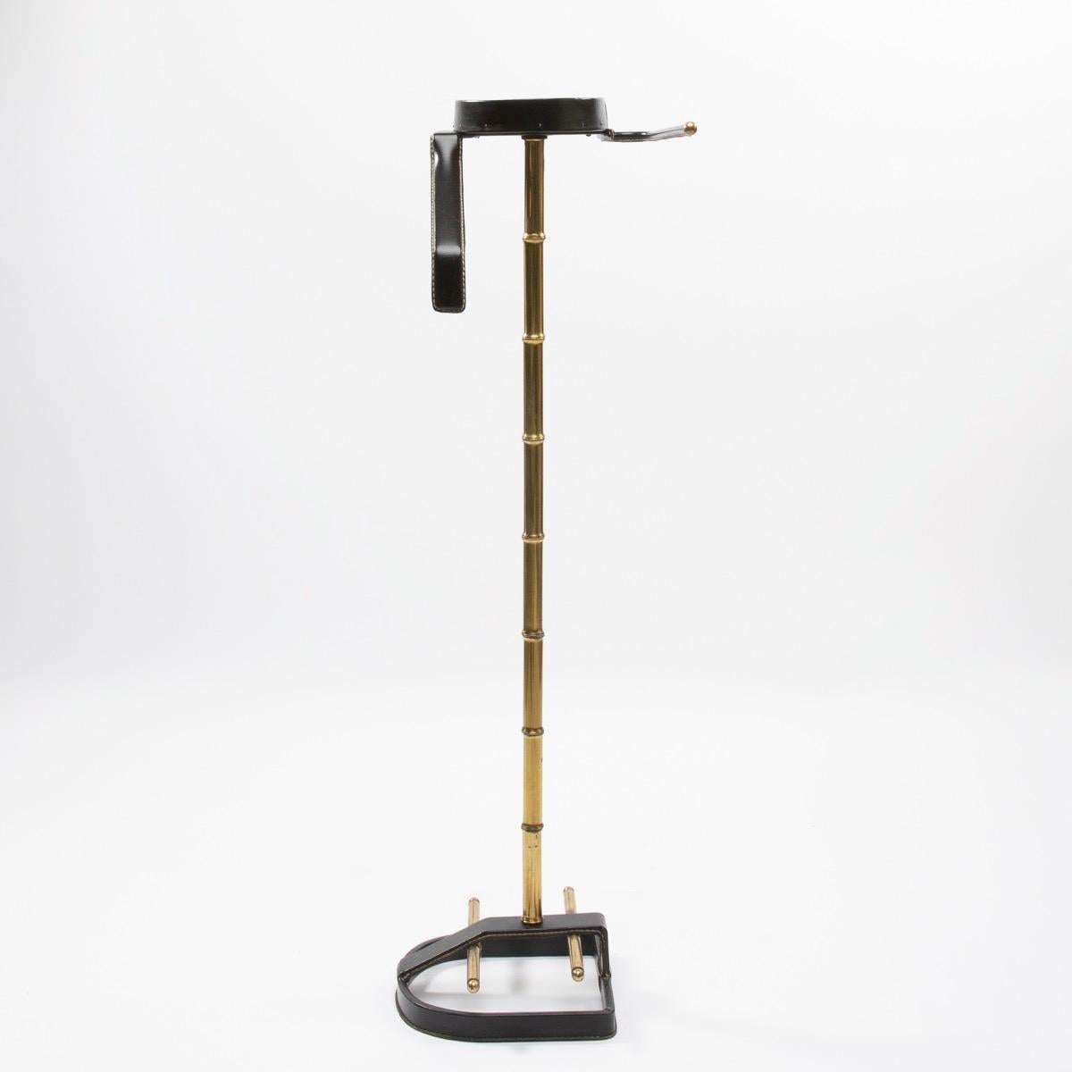 A valet by Jacques Adnet, (France), circa 1950.
Beautiful saddle stitched black leather work on a steel frame with brass accents (faux bambou central shaft).

Jacques Edouard Jules Adnet was born in Châtillon-Coligny France in 1900 and died in