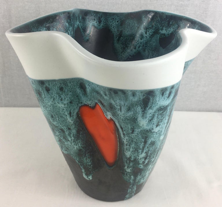 Beautiful earthenware vase with enameled decorations of orange-red pastilles placed on a background ranging from white to anthracite gray and blue speckled. The interior of the vase is also enameled black. It dates from the 1950s and is signed