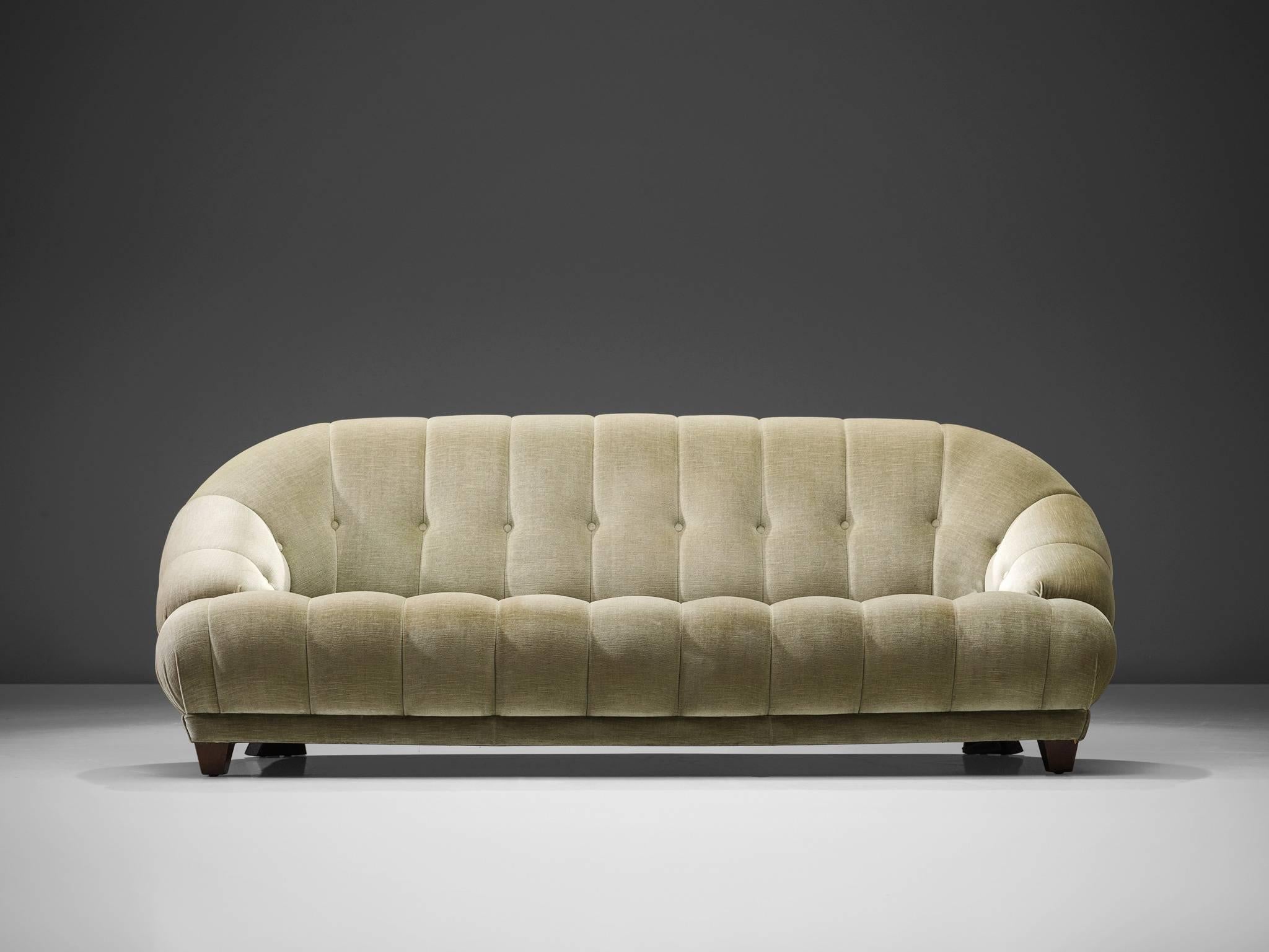 Sofa, green velvet, France, 1940s.

This voluptuous sofa in is executed in a green velvet fabric. The sofa has a curved back and very thick and wide armrests. The sofa is tufted and holds a balance between modern simplicity combined with