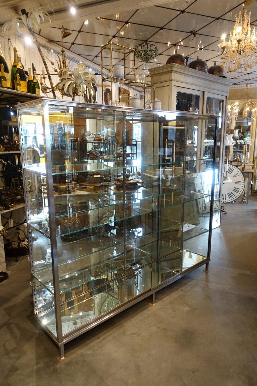 Special and completely unique vintage display case, in an elegant and beautifully streamlined design. This cabinet is a seldom find, with its long glass shelves, sliding doors and size. Originally from a glove shop in Lyon, where it has stood as a