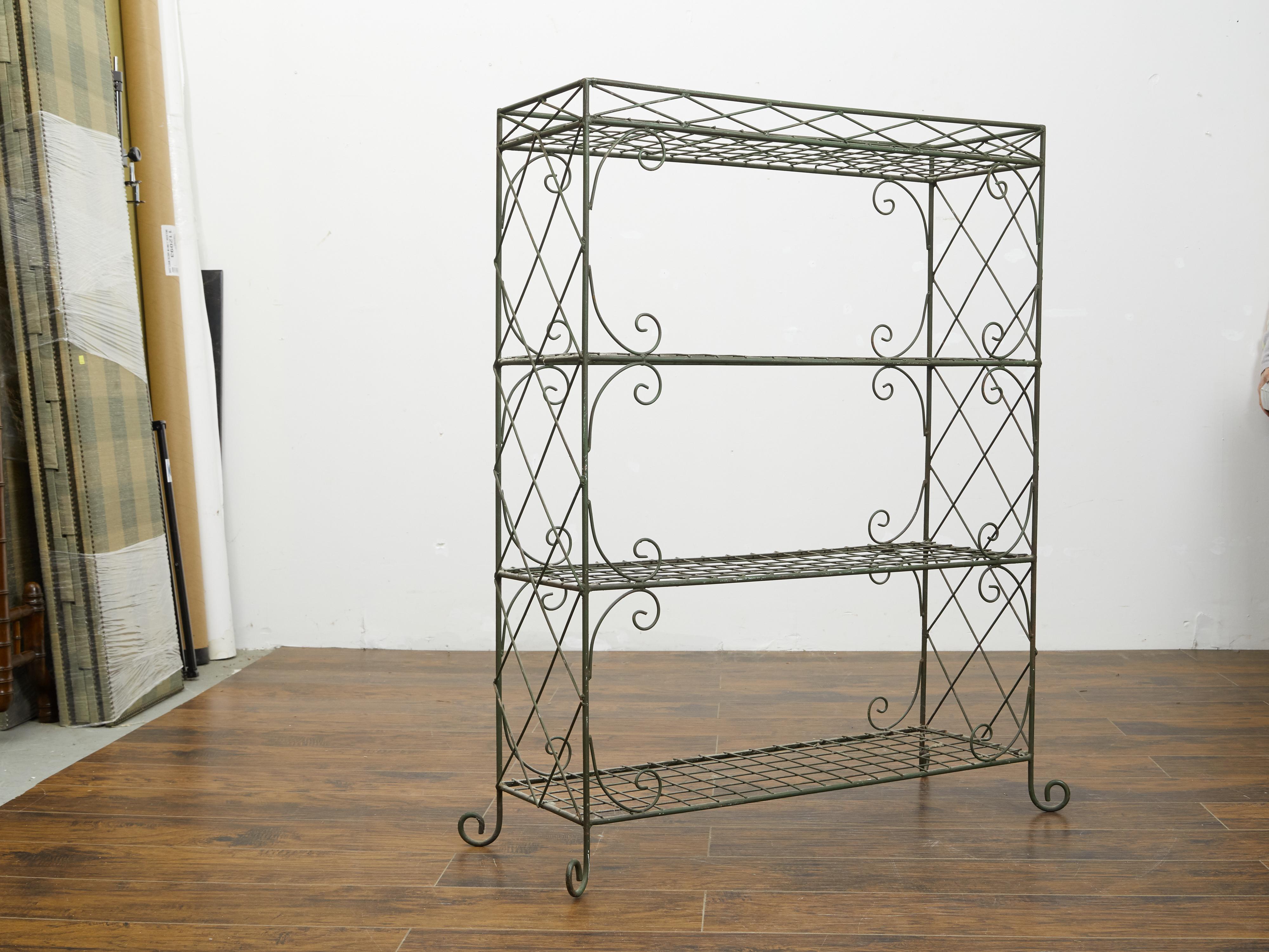 A vintage French wire freestanding shelf from the mid 20th century, with scrolling accents. Created in France during the midcentury period, this shelf attracts our attention with its wire structure adorned with diamond motifs and C-scrolls. Resting