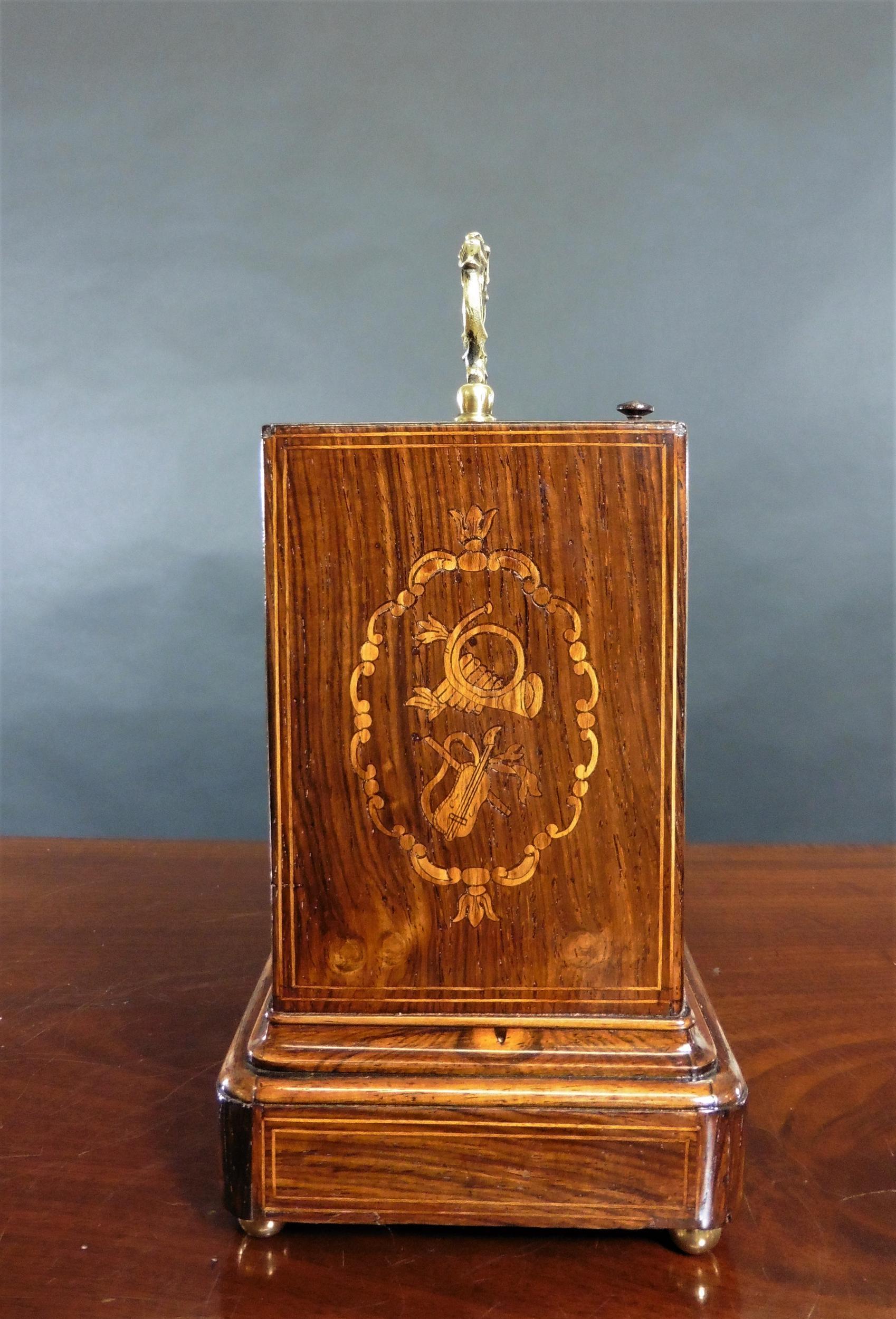 French Miniature rosewood Campaign clock

French miniature Campaign clock in a Rosewood case standing on a raised moulded plinth and inlaid with satinwood line stringing and floral decoration. Rising glass front with top glazed viewing aperture
