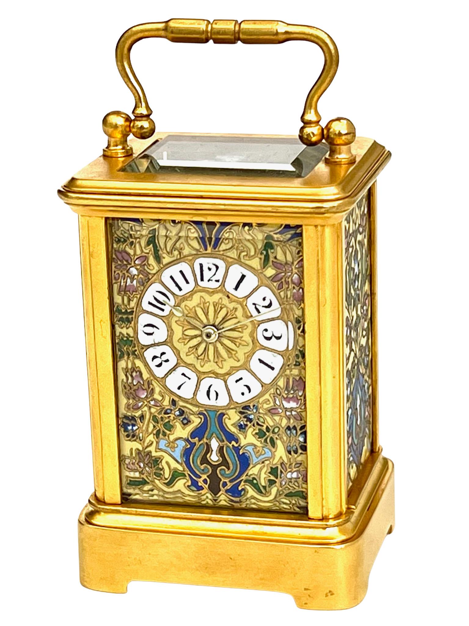 A stunning miniature eight day timepiece carriage clock with highly attractive and finely executed Champlevé enamel panels. The colour combination including rich yellow, greens and blues is quite unusual and seldom seen. The richly gilded miniature