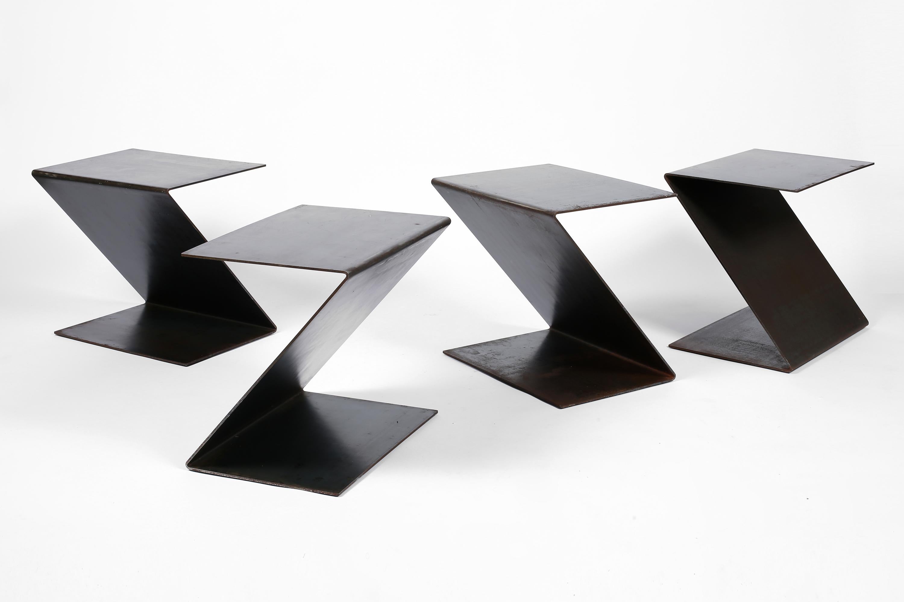 VENDU SÉPARÉMENT

Une série de quatre tables d'appoint ou tabourets formés à partir de feuilles d'acier patiné pliées. 
