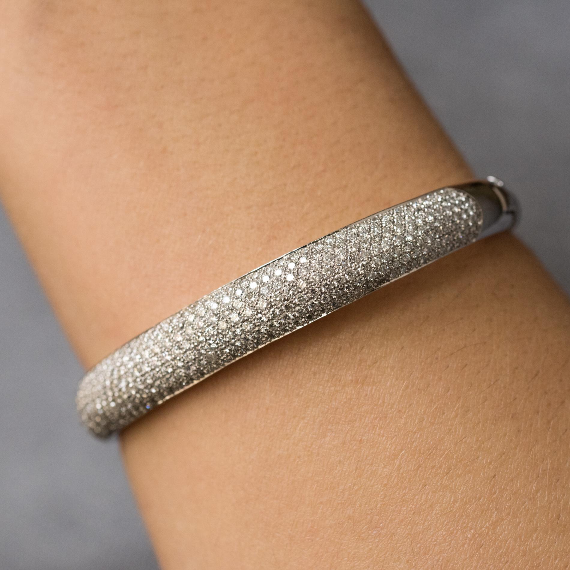 Bracelet in 18 karats white gold, eagle's head hallmark.
Bangle shape, oval, it is paved with diamonds on its top. It is opening on one side by a hinge, the interior is perforated. The clasp is a ratchet with a diamond set on the thumb