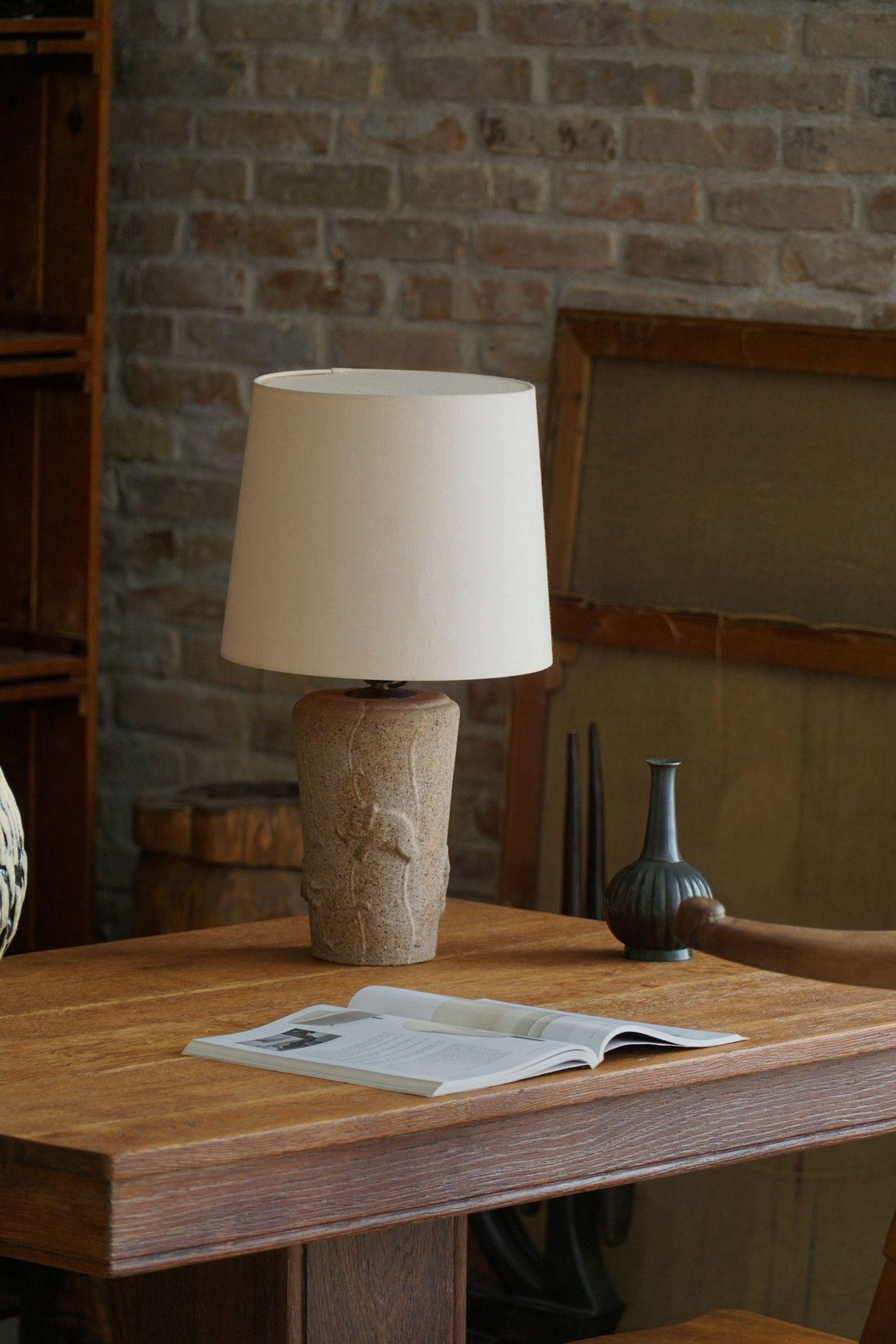 Charmante lampe de table en pierre datant du milieu du siècle dernier. Fabriqué en France dans les années 1970. La Nature présente une base en pierre unique, ornée de motifs d'éléphants complexes, mêlant éléments naturels et élégance artistique. Son