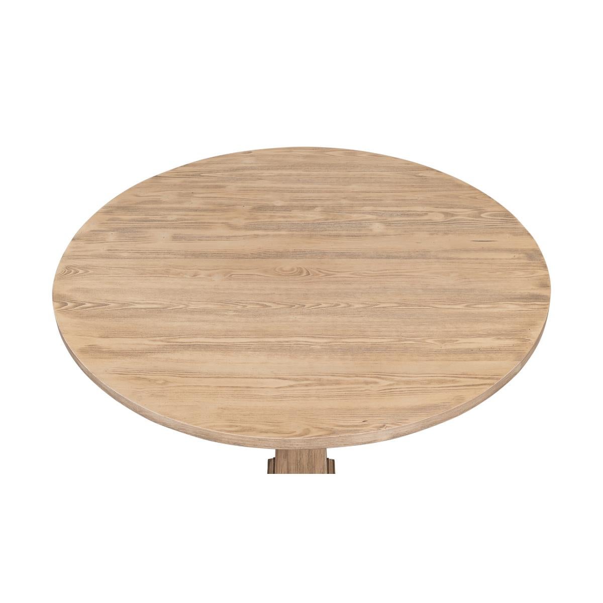 Table de bistrot moderne française avec un plateau rond en pin sur une base à piédestal en forme de colonne effilée.

Dimensions : 36