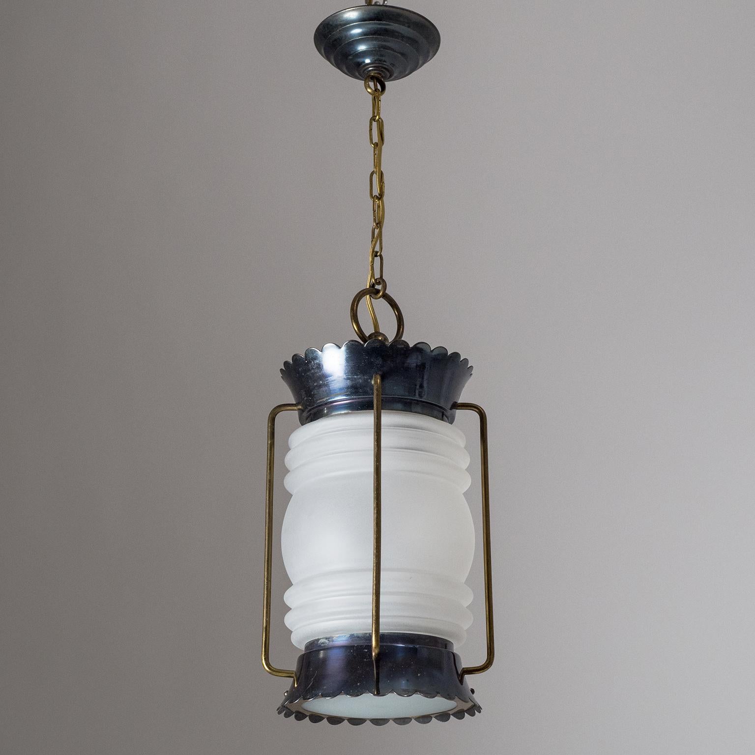 Superb French midcentury lantern taking a modernist approach to marine-style lighting. The hardware is made entirely of brass with the canopy and the scalloped top an bottom parts patinated very darkly with a slight purple tint. The fresnel glass