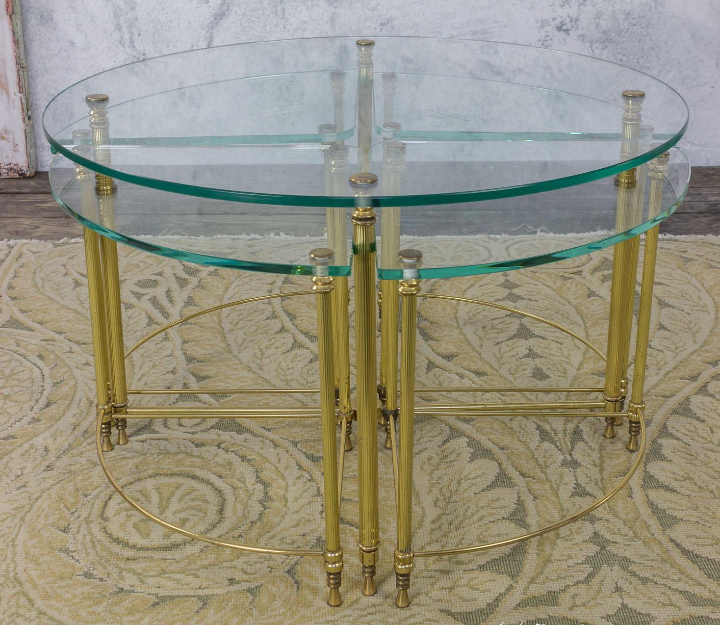 This French 1970s round clear glass sectional coffee table is a distinctive piece, featuring a polished brass frame that beautifully complements the transparency of the glass. The table is composed of five pieces in total: a larger round coffee