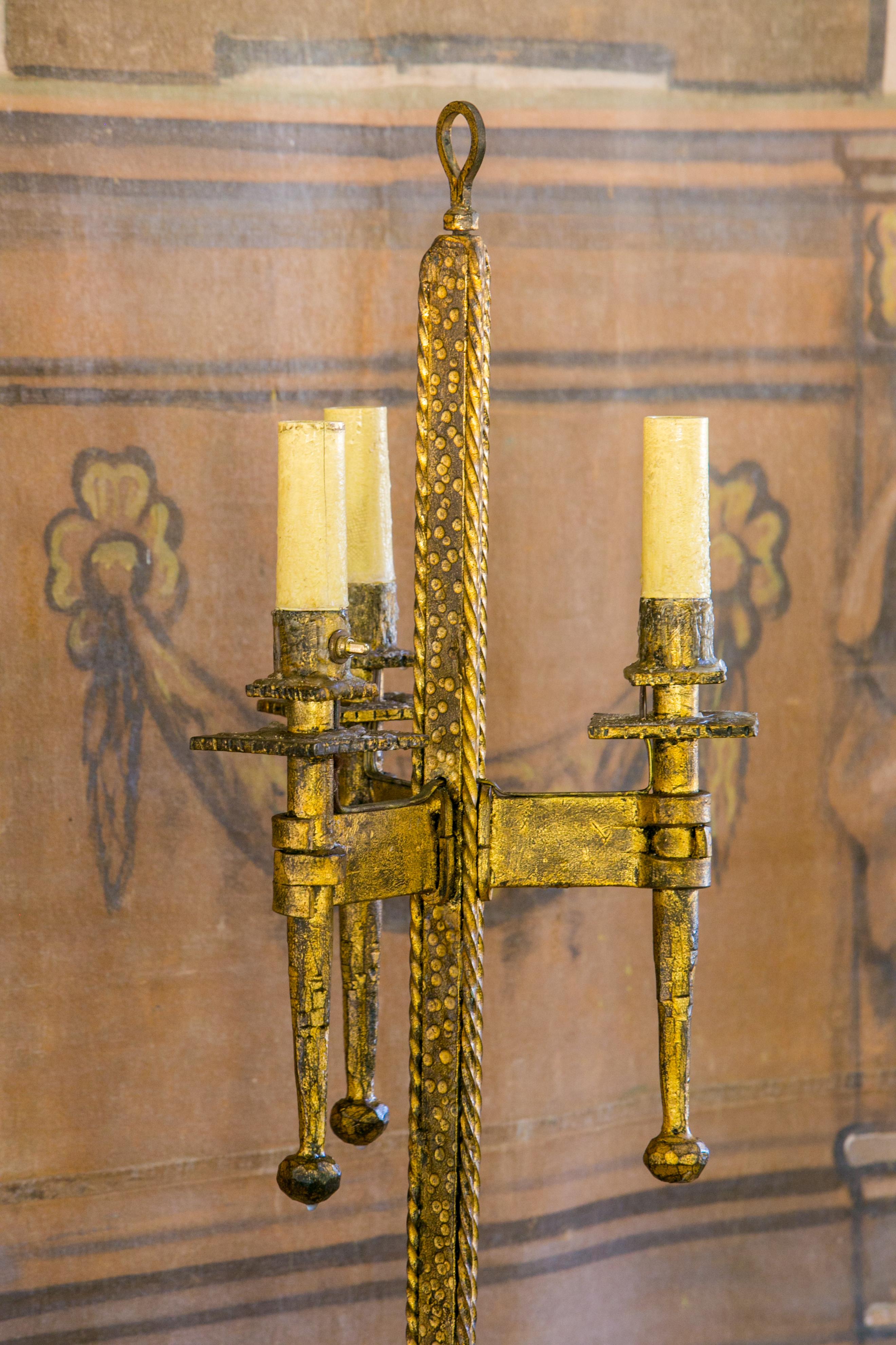 Brutalist gilt-iron floor lamp from the 1940s. This French modern lamp is in a nice, good condition. Hammered forged iron decorated in its original gilt finish. Newly wired for use within the USA with three new candelabra-size sockets encased in the