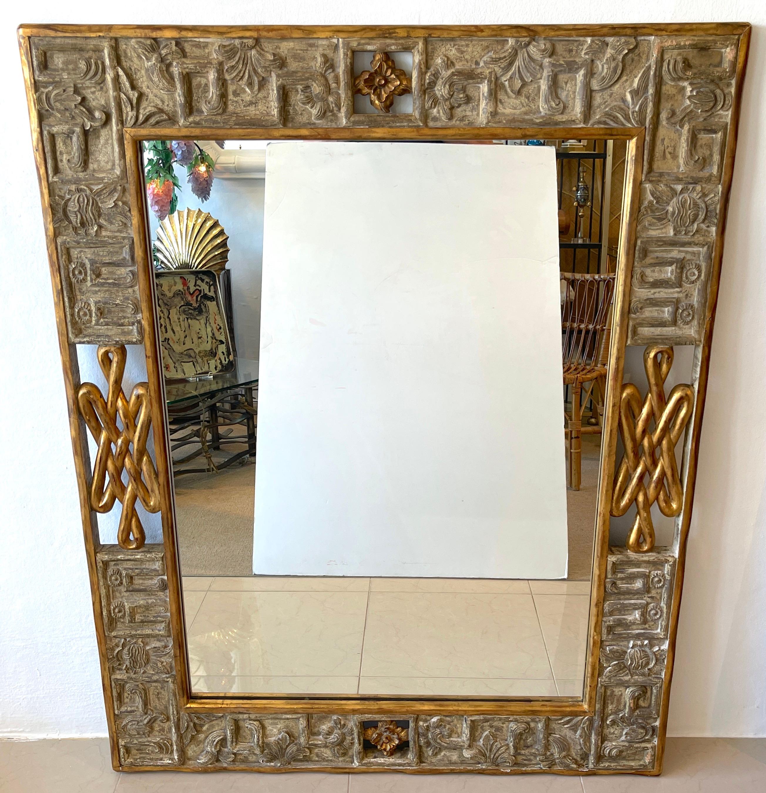 French Modern Carved Gilt & Silver Wood Mirror
France, Late 20th Century 
A substantial hand carved work, the continuous surround, with pierced giltwood rosettes and elements with alternating silver-leaf relief carvings. The inset mirror measures