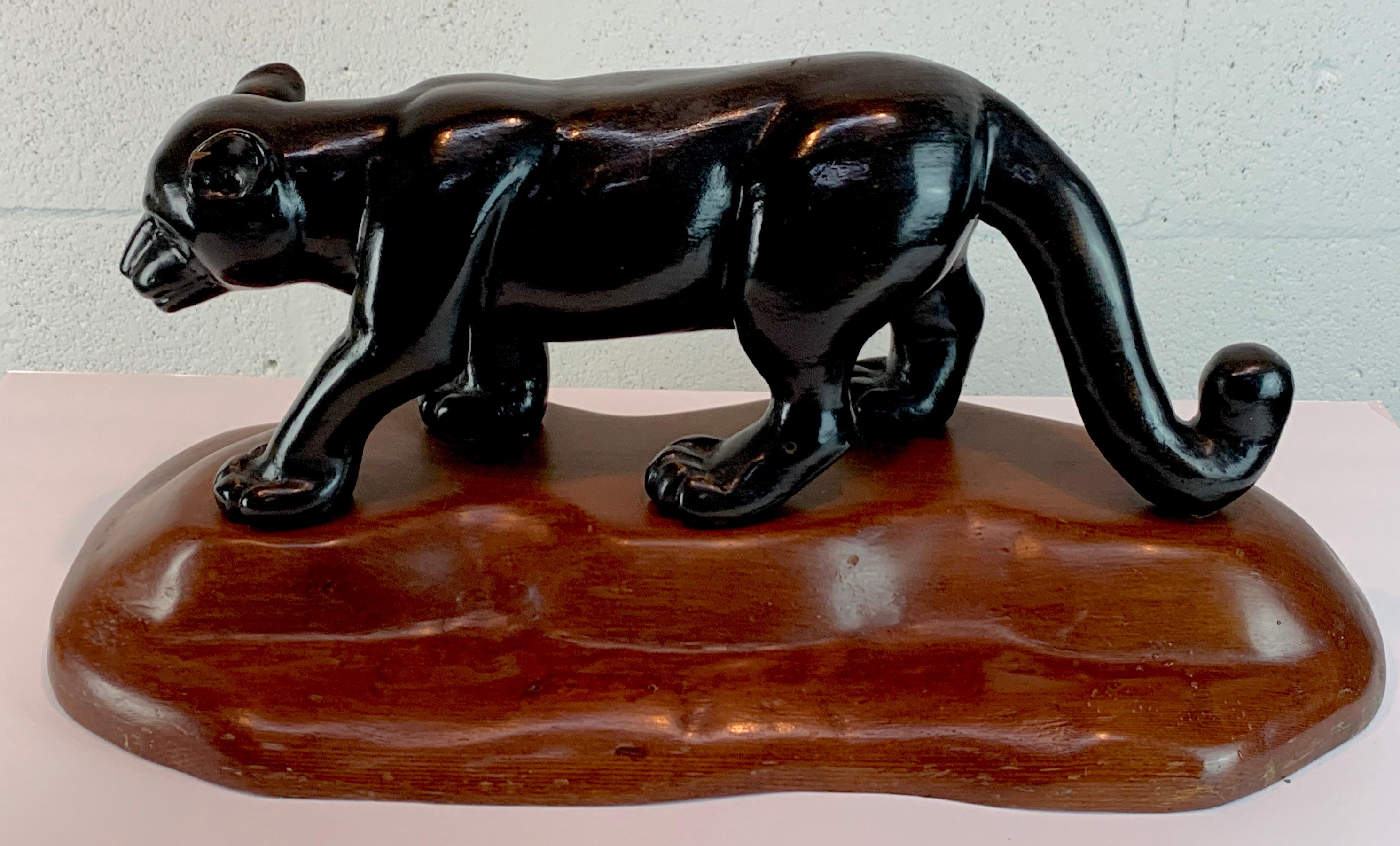 French modern carved wood sculpture of black panther/ jaguar, well carved ebonized walking black panther/ jaguar on a natural rockwork base.
The base measures 22.75 x 11