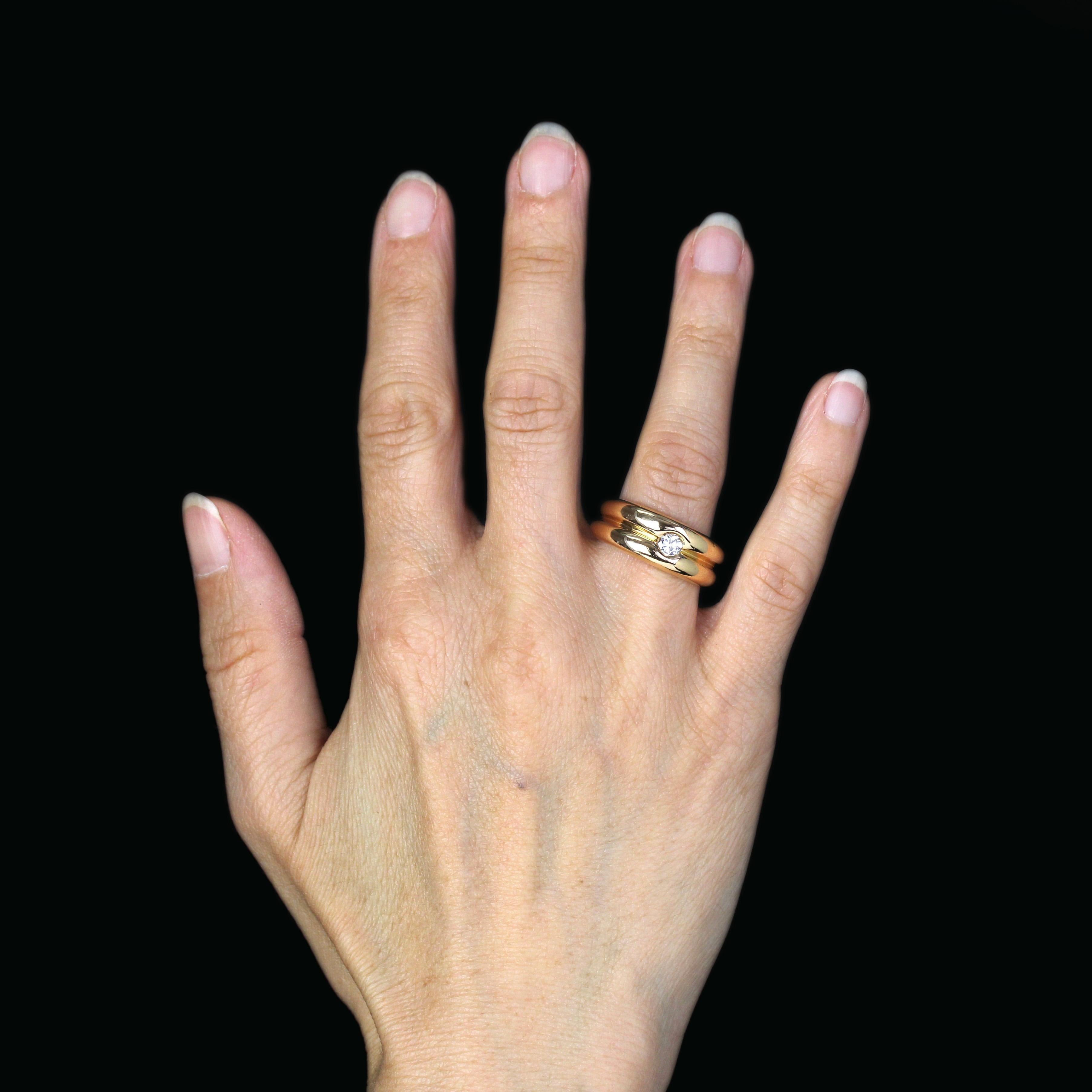 Anillo de oro amarillo de 18 quilates, sello de cabeza de águila.
Elegante anillo brazalete, está constituido por dos brazaletes abombados unidos entre sí y decorados en el centro con un moderno diamante talla brillante.
Peso del diamante : 0,18