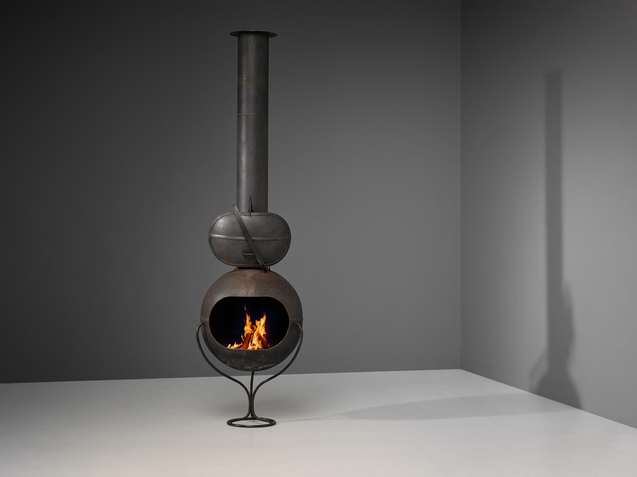Fire place, sheet steel, France, 1960s.

A well-designed fire place executed in black coated steel, ably employed as either the heart of a decor or its focal point. The whole construction is based on a sphere shape that can be opened with a steel