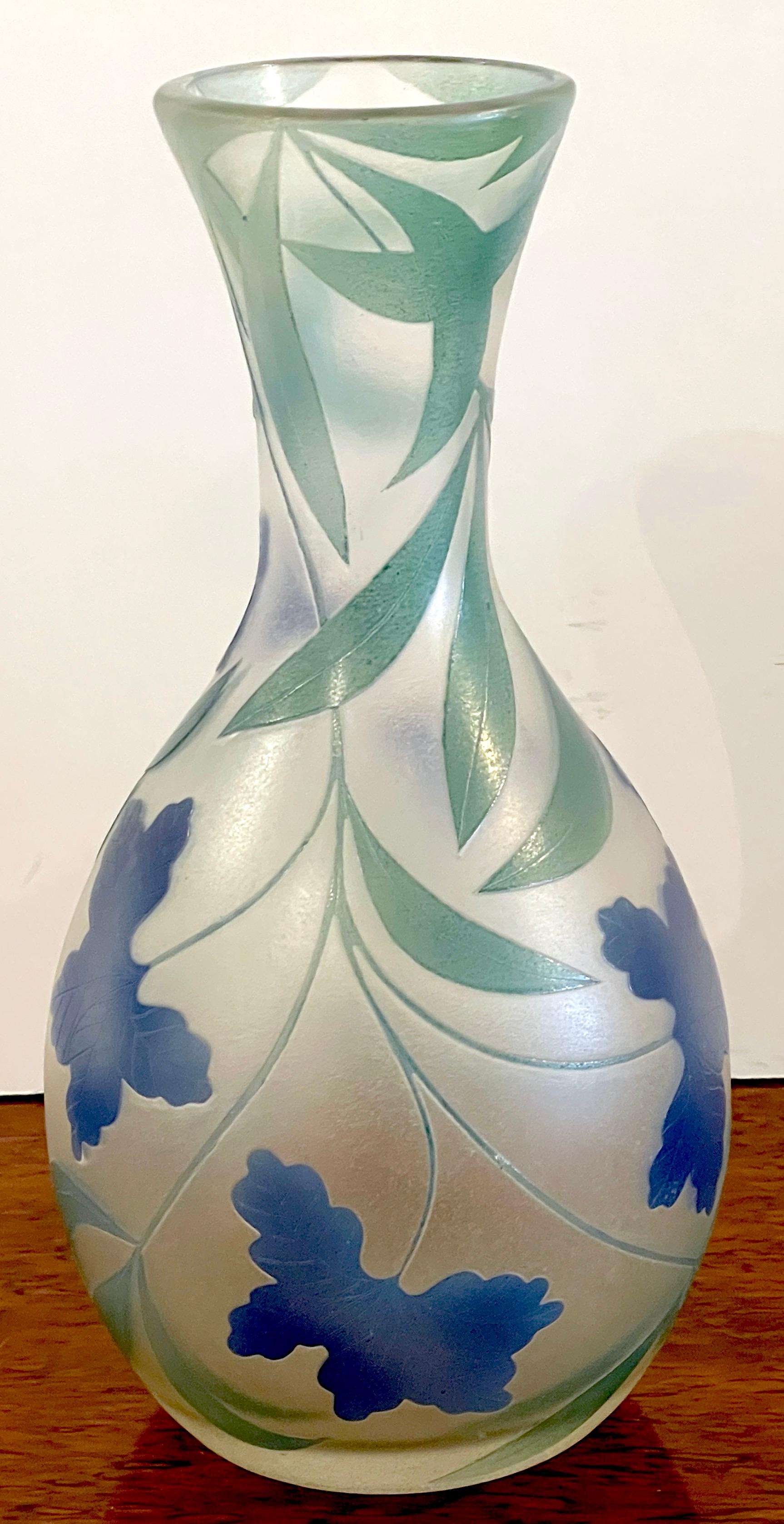 French Modern Floral Cameo Glass Vase, Signed Daum+Nancy France 
France, 20th Century 
Signed in script signature 'Drum +Nancy-France'

The vase fitted with a long neck, subtle minimal cameo blue floral and green leaves, on bulbous body with all