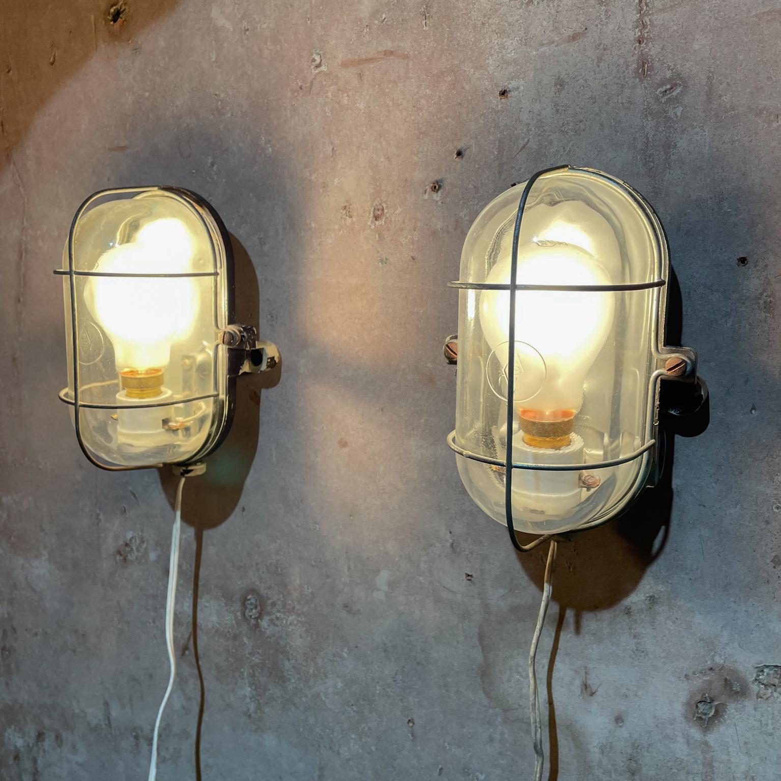 Vintage wall lights
Pair of French wall sconces Industrial Design. Made in France.
Measures: 7.5 H x 5 W x 4.25 inches
Hard plastic shell appears as Bakelite has perforation to attach to the wall. 
Metal grid shell covers a protective glass