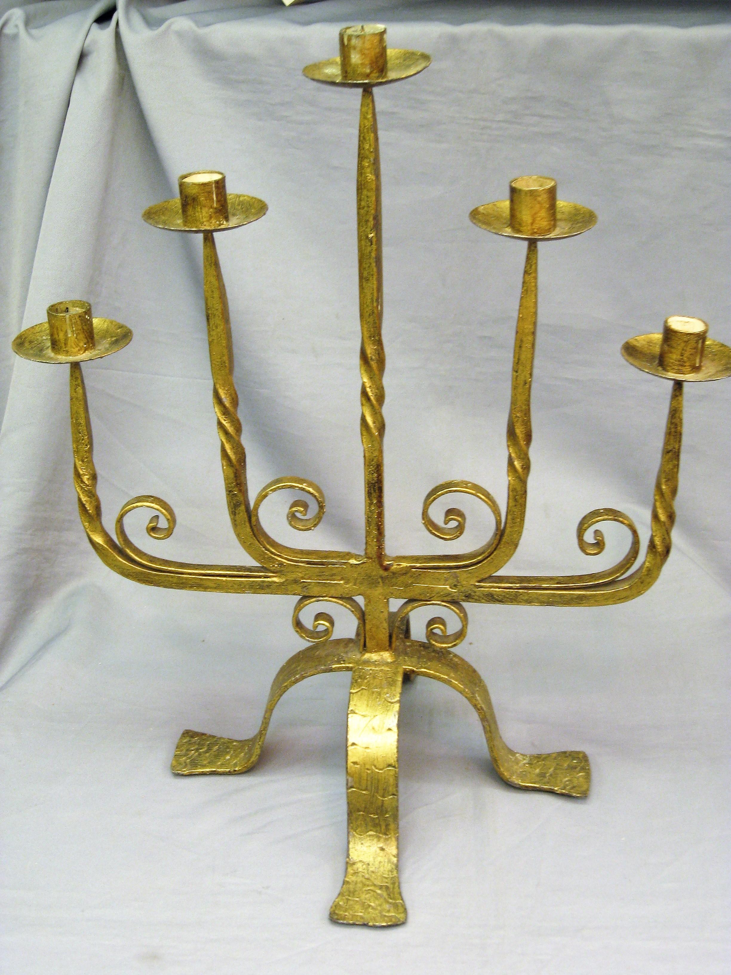 Large French hammered iron gold leafed candle holder. Five arms or candle branches with four arched leg base, twisted arms and scroll details.
Can be used as a centerpiece on a dining room table or console in a Minimalist or even Gothic decor as