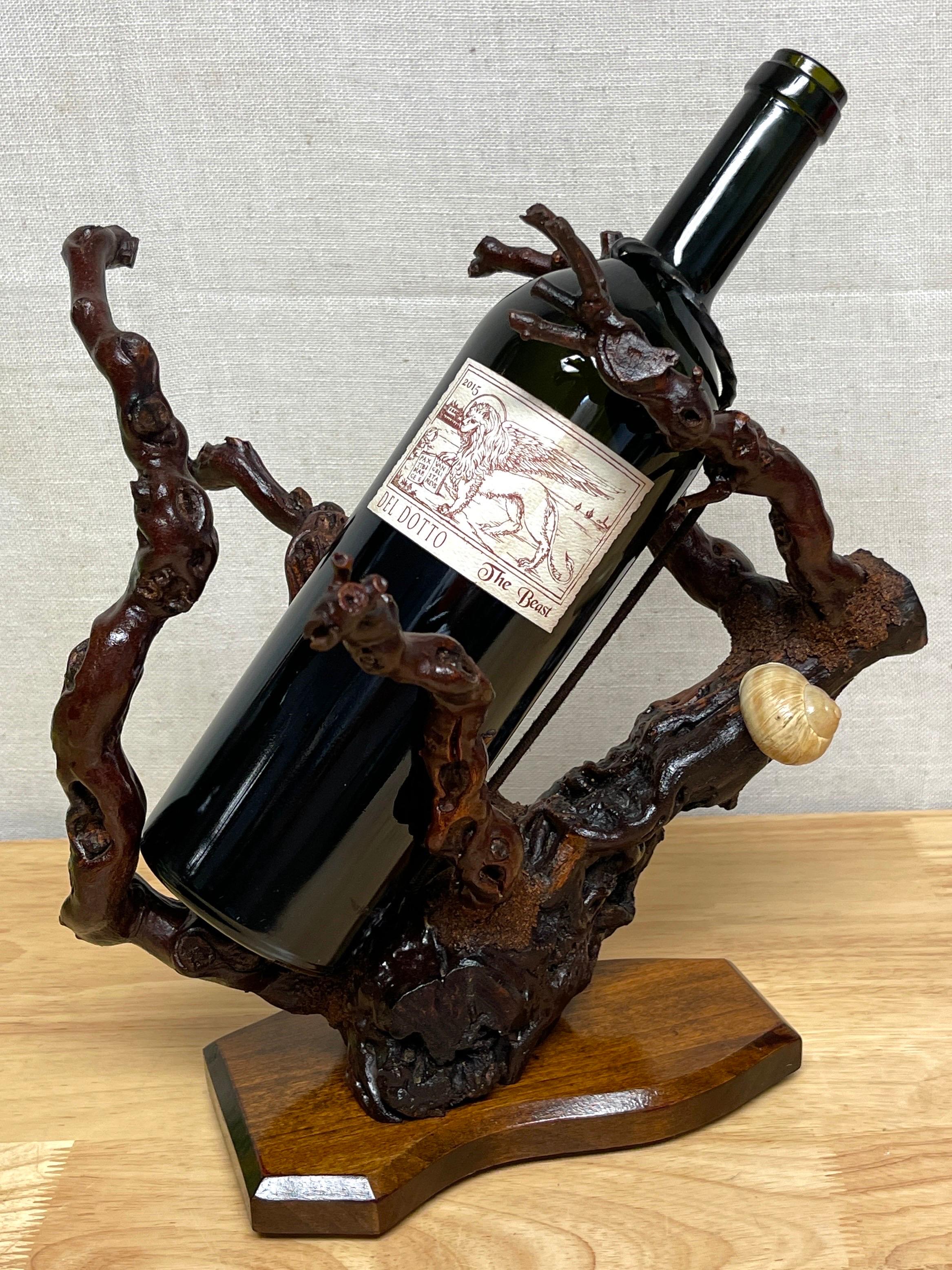 French modern natural grapevine ‘Coral’ wine caddy 
France, Circa 1960s 

A spectacular natural specimen grapevines articulated to emulate coral branches, holds a standard wine bottle with ease, complete with the blackened metal drip ring, and