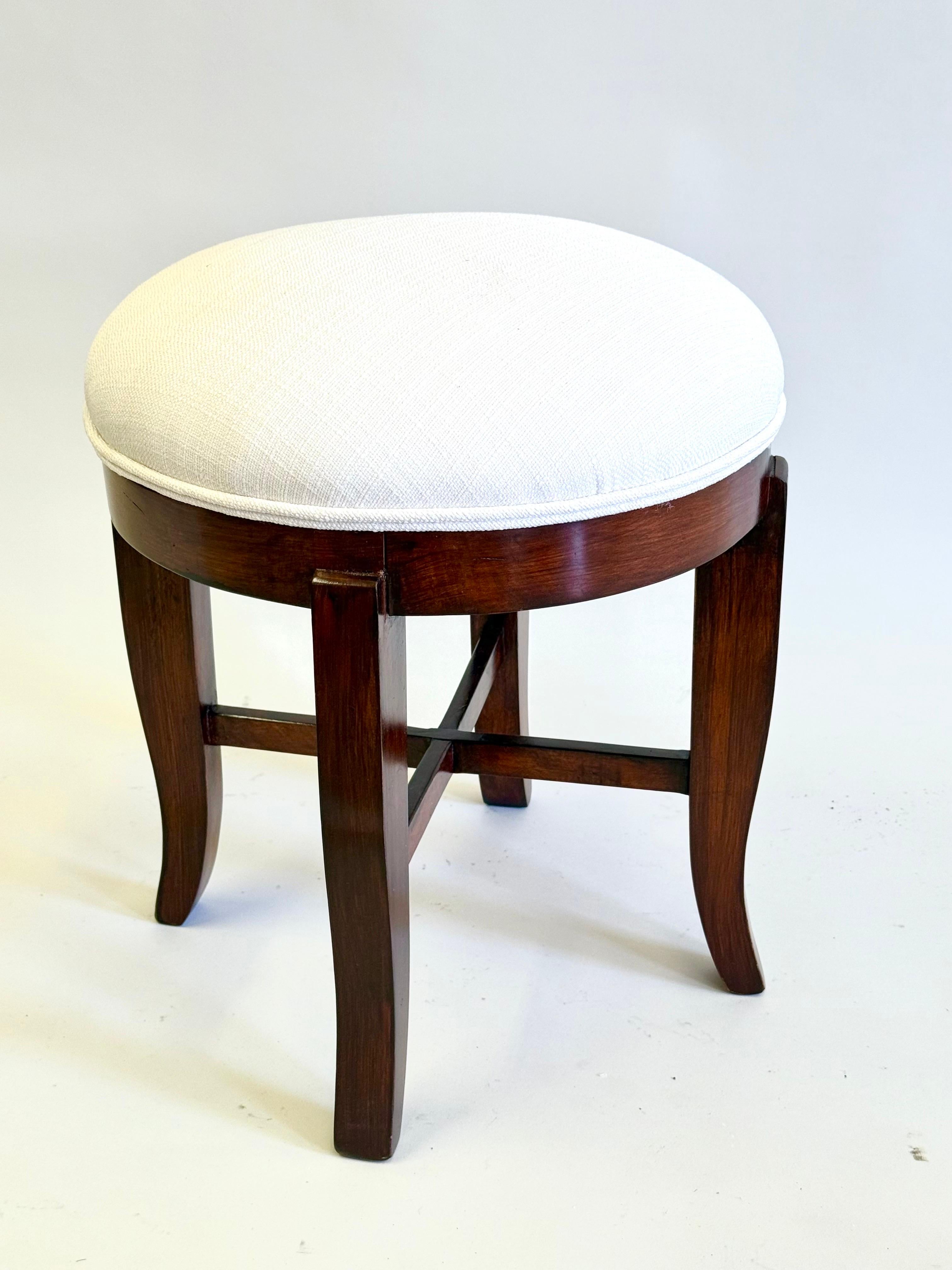 Un élégant et intemporel tabouret / banc néoclassique ou Art déco tardif en acajou massif dans le style de Jean Michel Frank. La pièce est un modèle classique et sobre d'encadrement en X, les montants formant un cadre.  an X. Jean-Michel Frank a